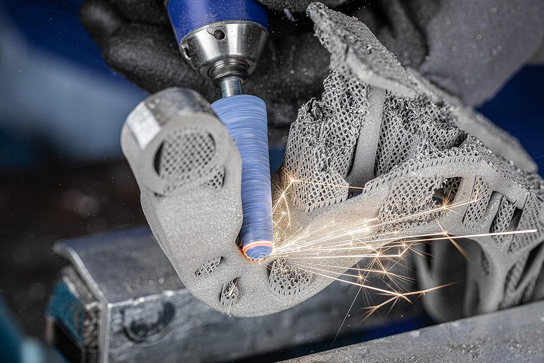 Eine Maschine schleift und poliert ein Metallteil. Funken fliegen vom Teil ab.