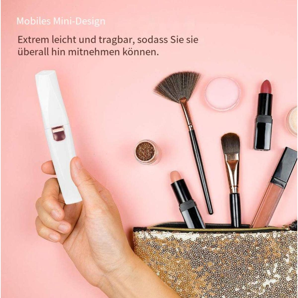 Eine Hand hält einen weißen Epilierer. Make-up-Artikel und eine Tasche liegen auf einer rosa Oberfläche.