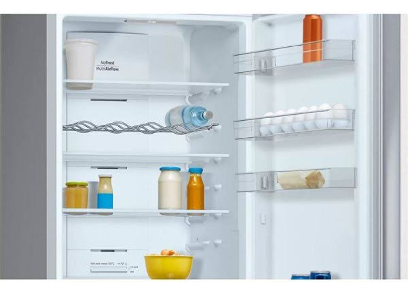 Refrigerador abierto. Estantes con frascos, botellas, huevos y alimentos. Interior blanco.