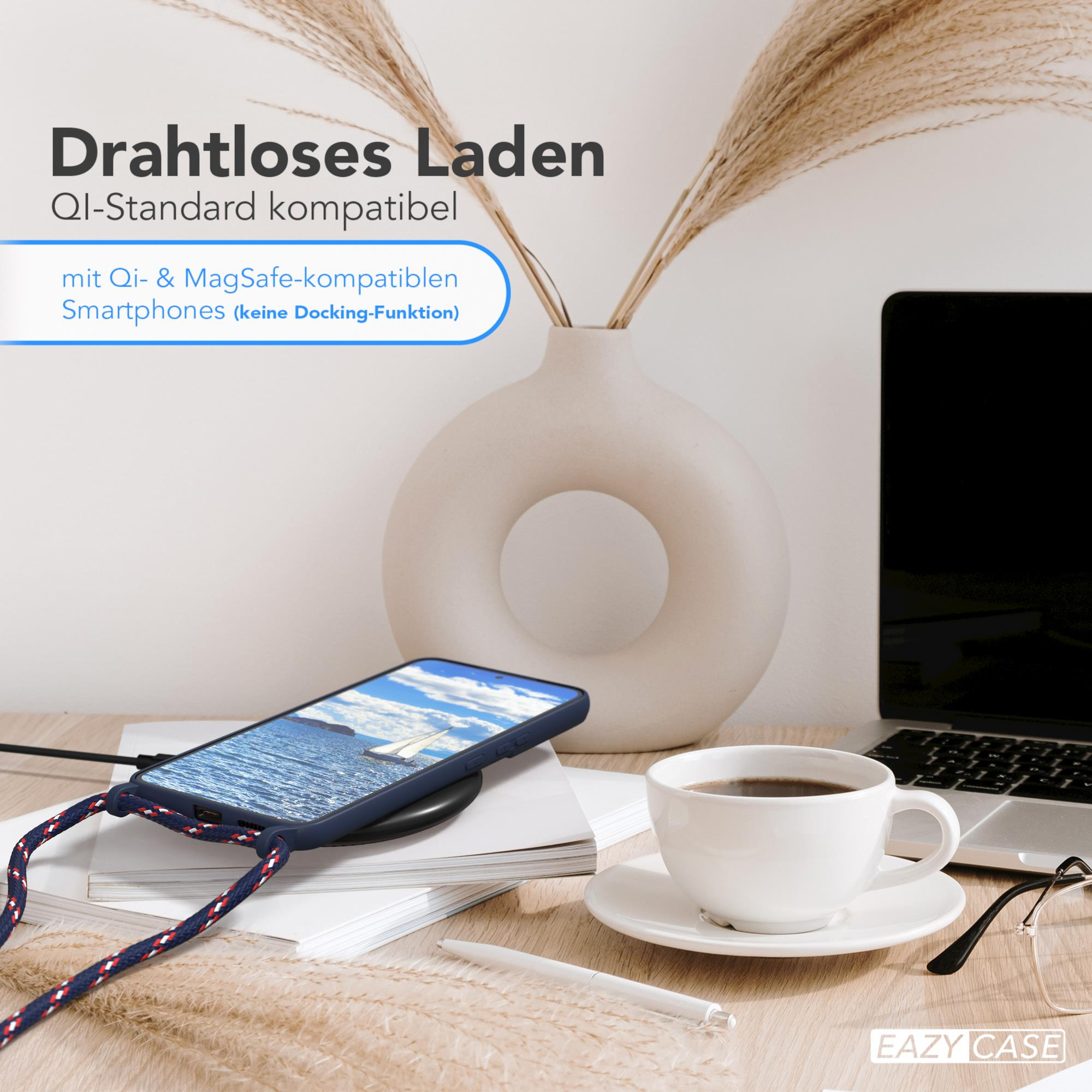 Ein Telefon wird kabellos geladen, neben einer Kaffeetasse, Vase und Laptop auf einem Holzschreibtisch.