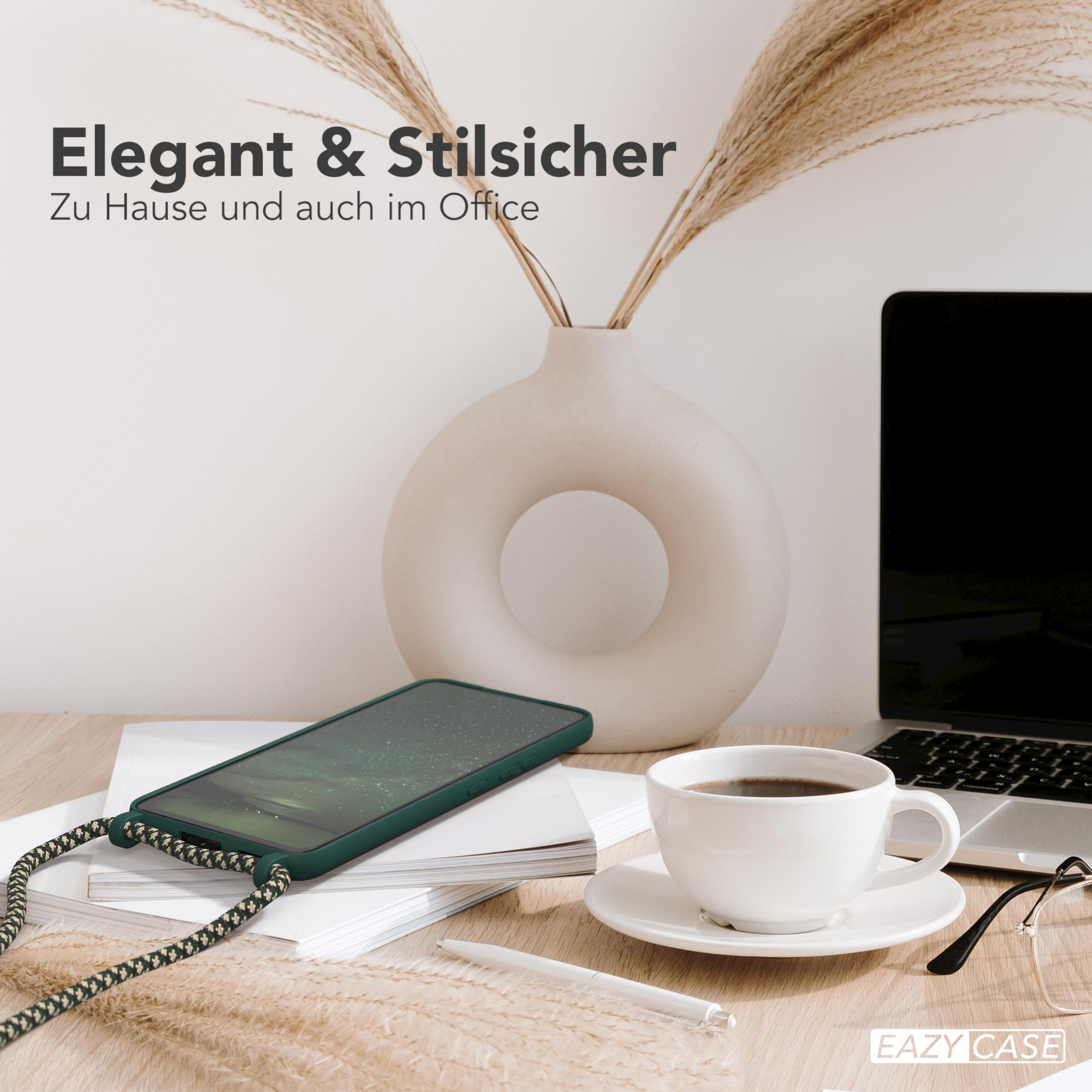 Ein Telefon mit Band, Laptop, Kaffee und Brille auf einem Holztisch mit Pflanzen.