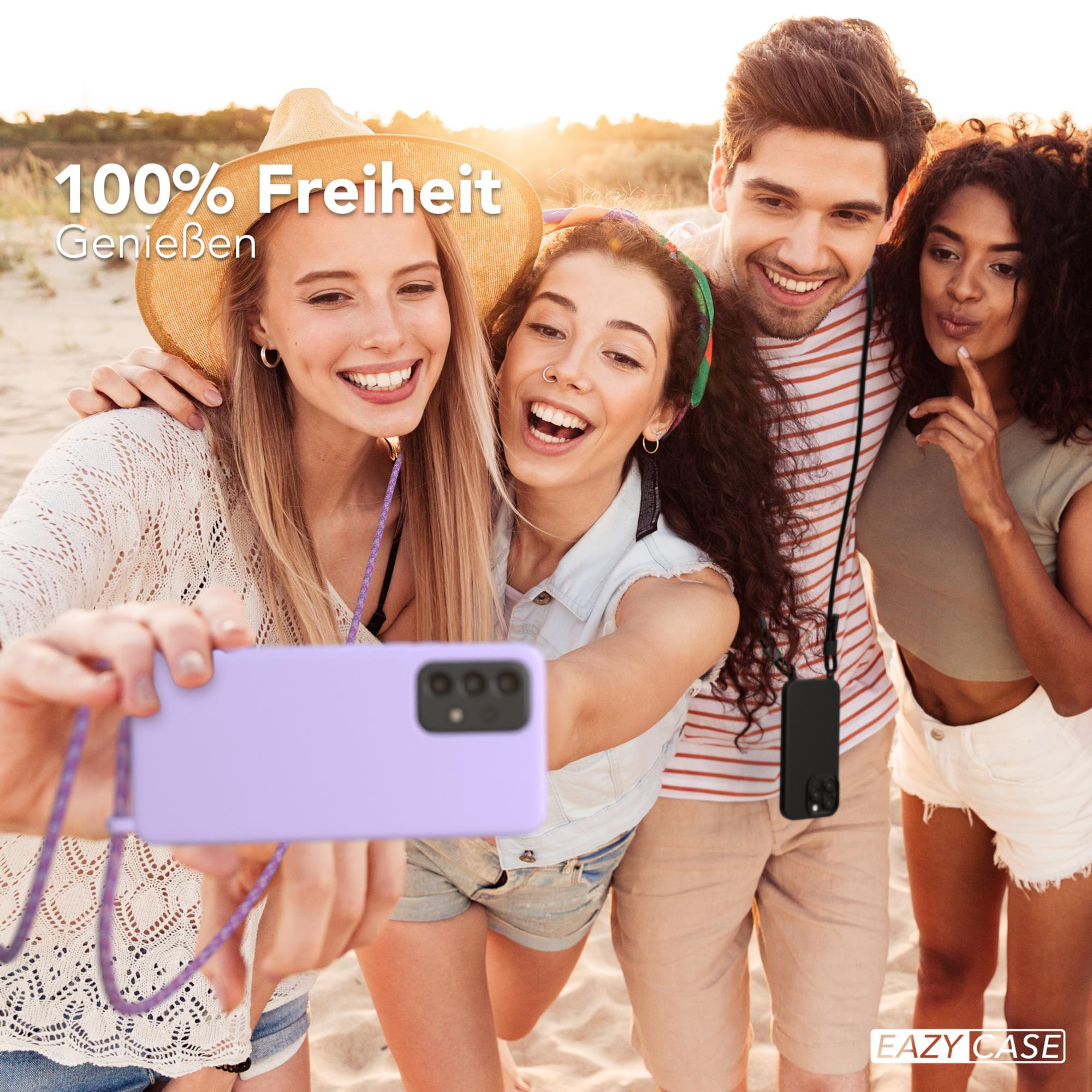 Vier Freunde machen ein Selfie am Strand. Einer hält ein lila Telefon mit Lanyard.