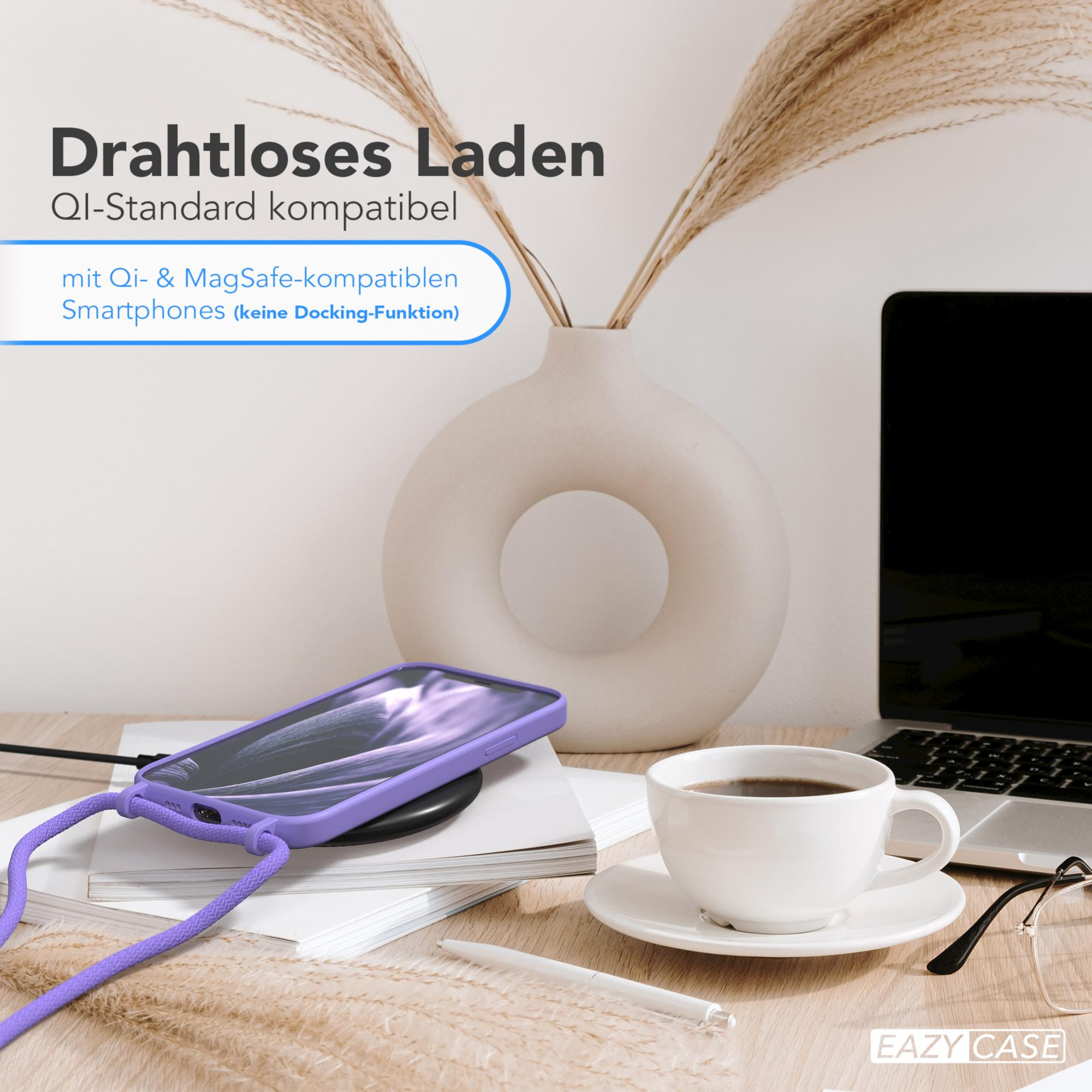 Ein Telefon auf einem kabellosen Ladegerät neben einer Kaffeetasse, einem Stift und einer Vase. Das Telefon hat eine lila Hülle.