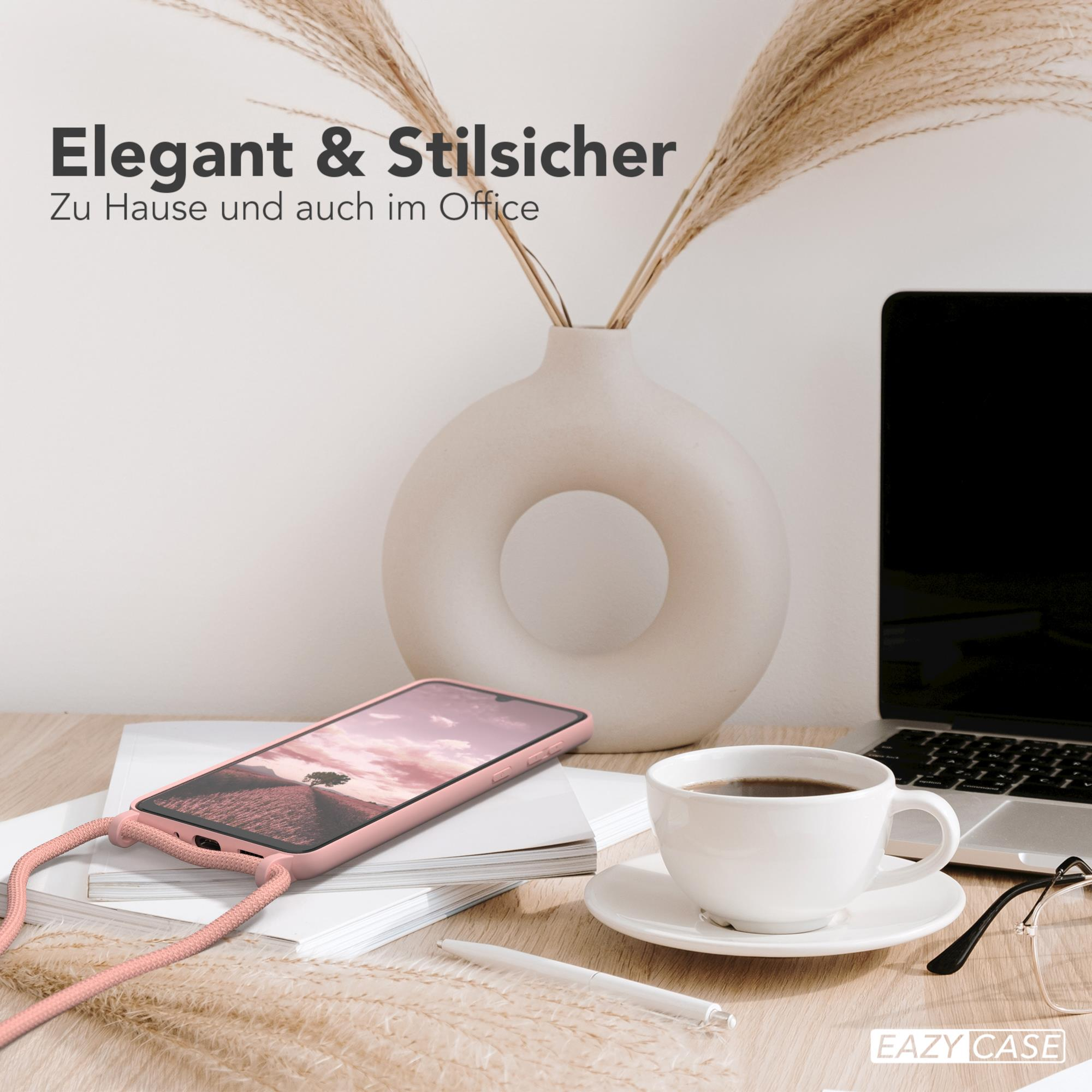 Ein Schreibtisch mit Telefon, Kaffeetasse, Laptop und Trockenblumen. Weiße Vase auf dem Tisch.