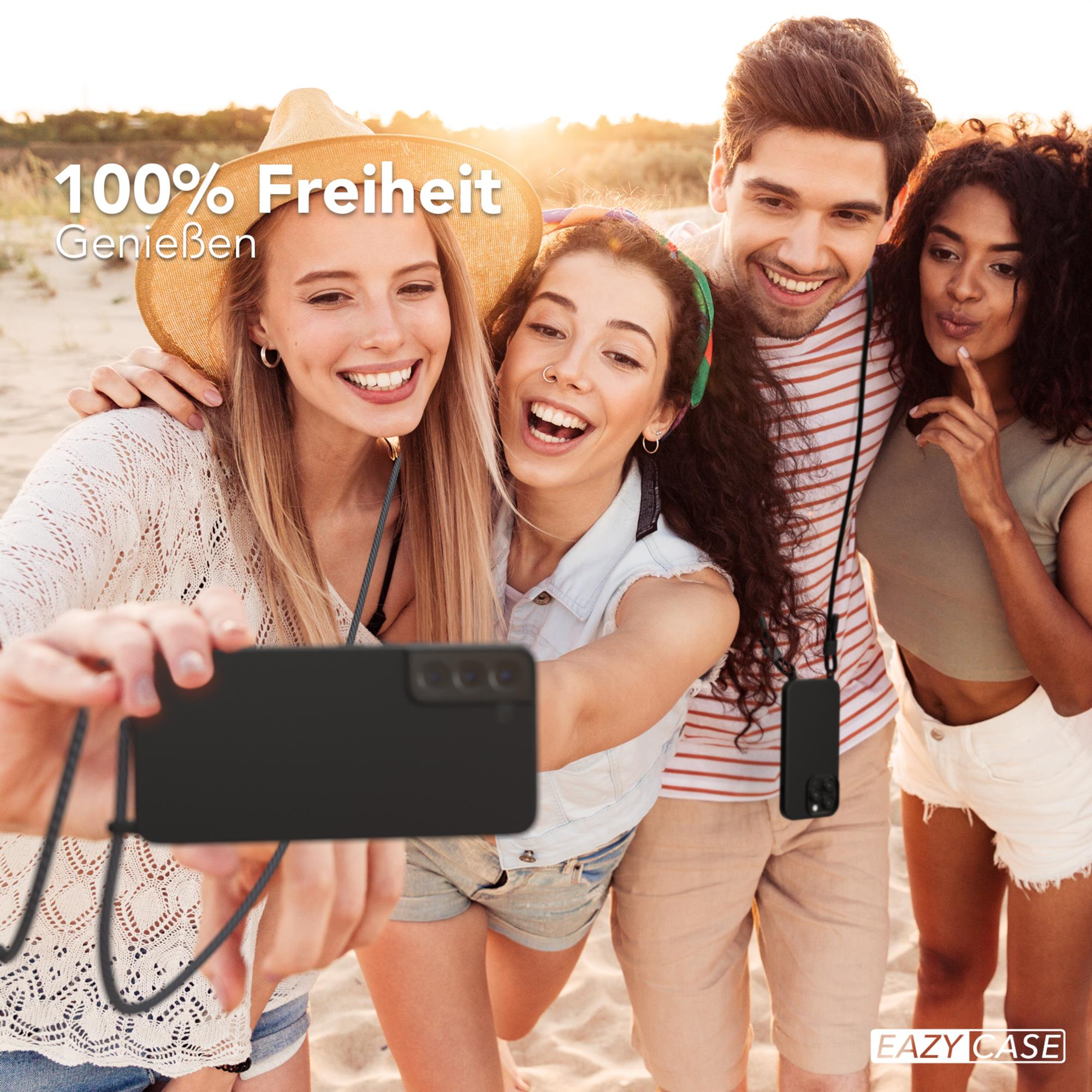 Vier Freunde machen ein Selfie. Einer hält ein Telefon mit einer Handyhülle an einem Schlüsselband.