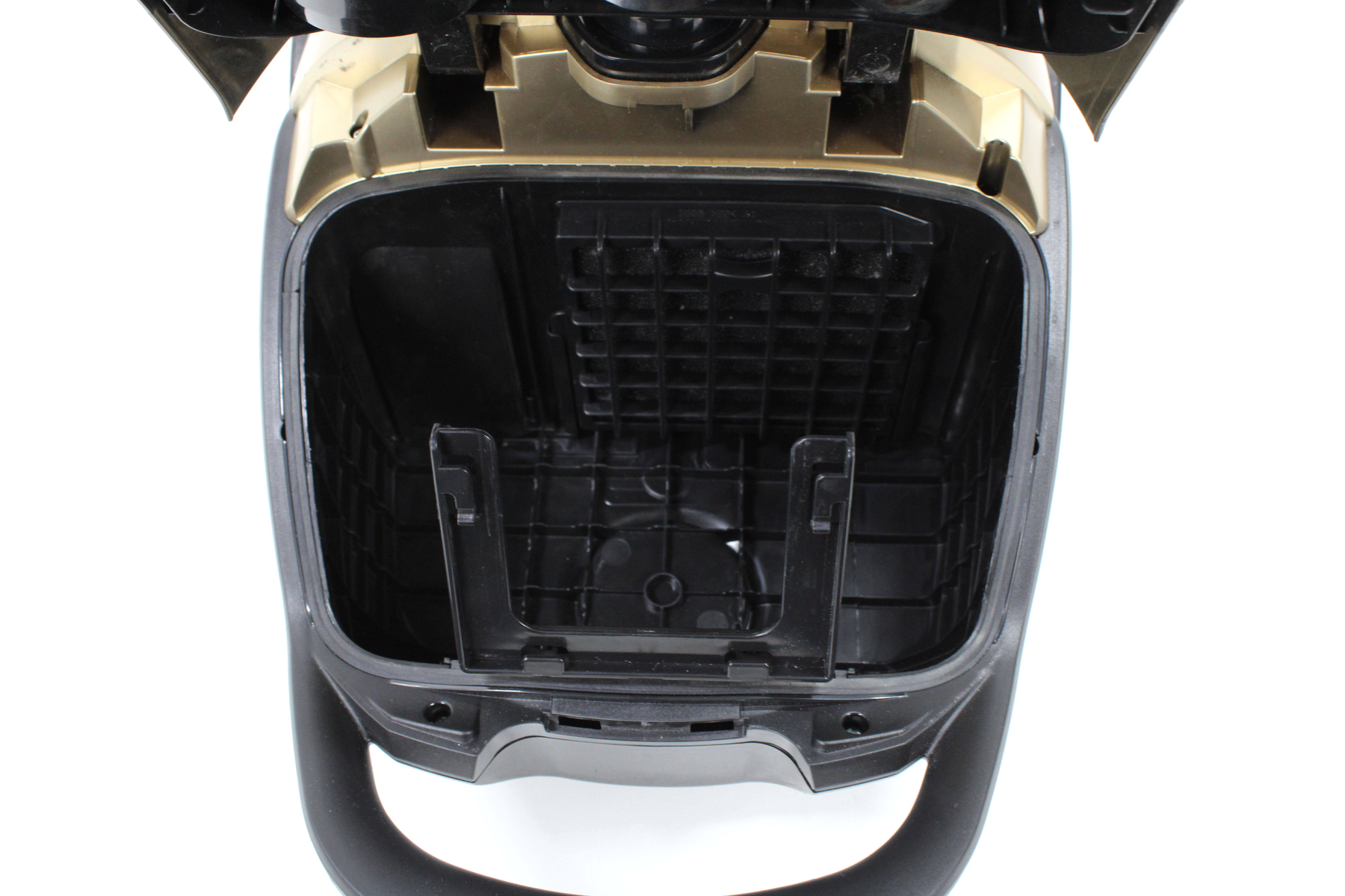 Intérieur d'un aspirateur noir avec le dessus ouvert. Une grille est visible à l'intérieur du compartiment.