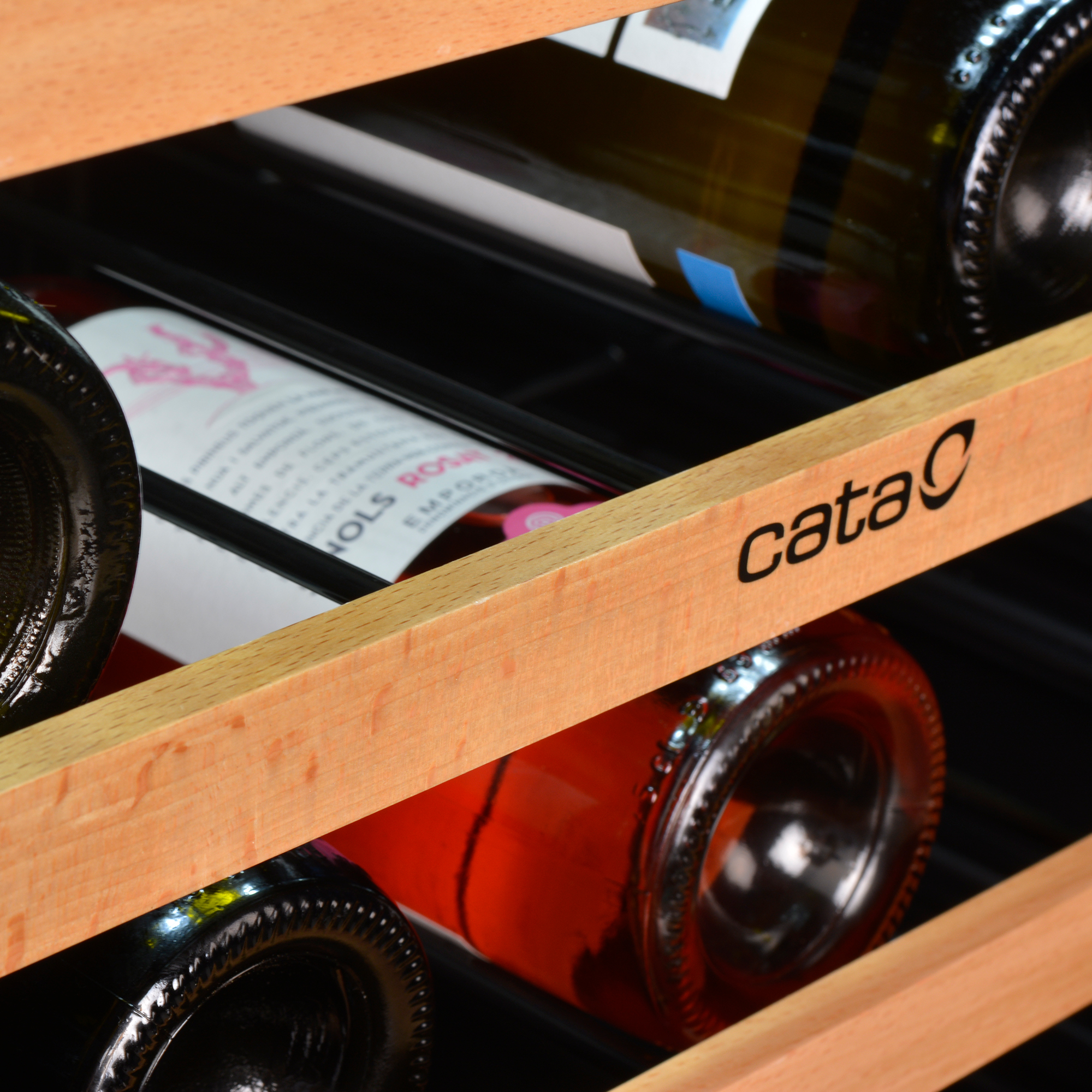 Botellas de vino en un estante de madera, con el logo de Cata.