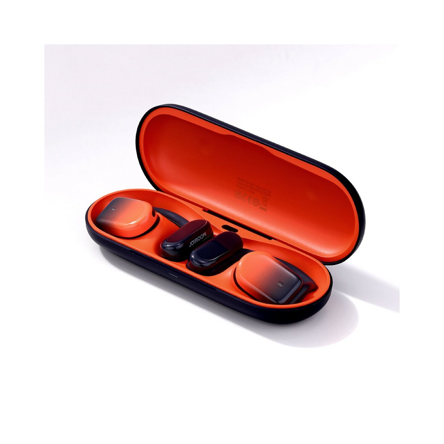 Otwarty pomarańczowo-czarny futerał z wkładkami dousznymi i etui ładującym.