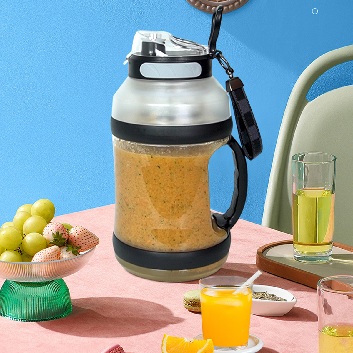 Große Wasserflasche mit Smoothie, Früchte und Saft auf einem Tisch. Blauer Wandhintergrund.
