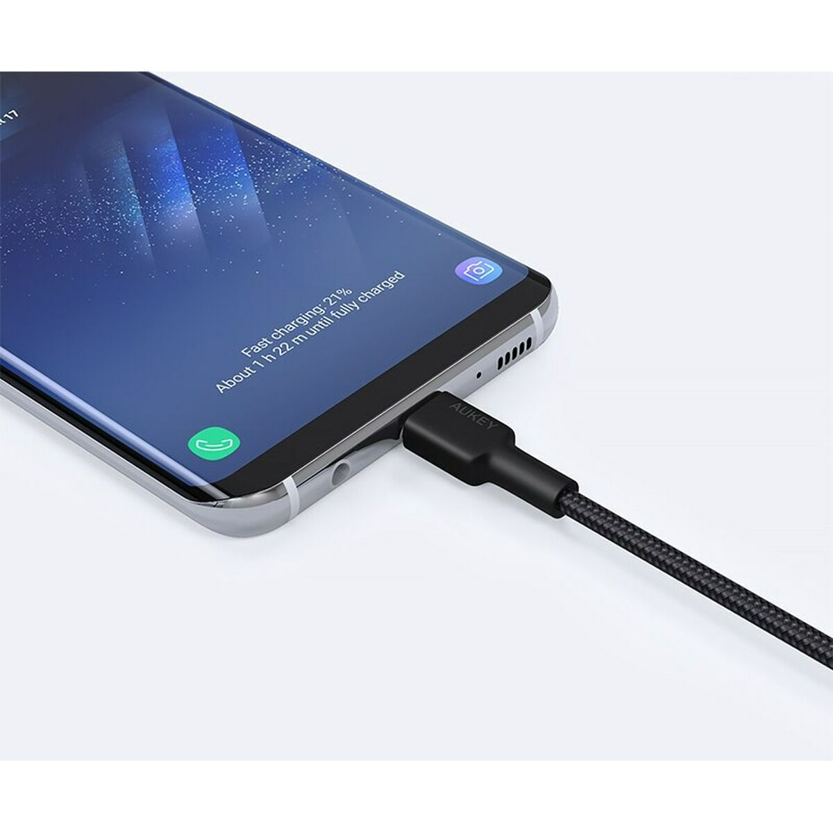 Un telefono in carica con un cavo nero.