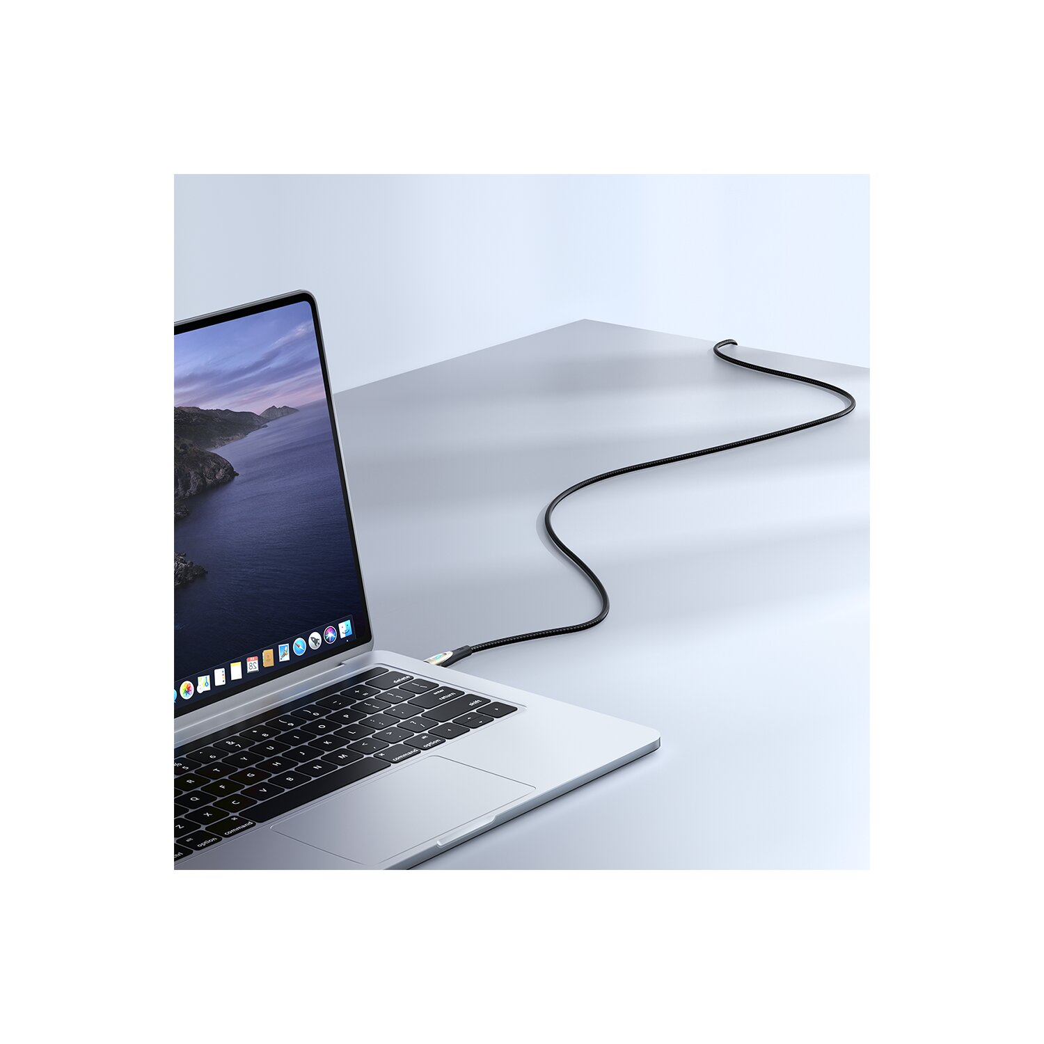 Laptop, der über ein schwarzes Kabel mit einer hellen Oberfläche verbunden ist.