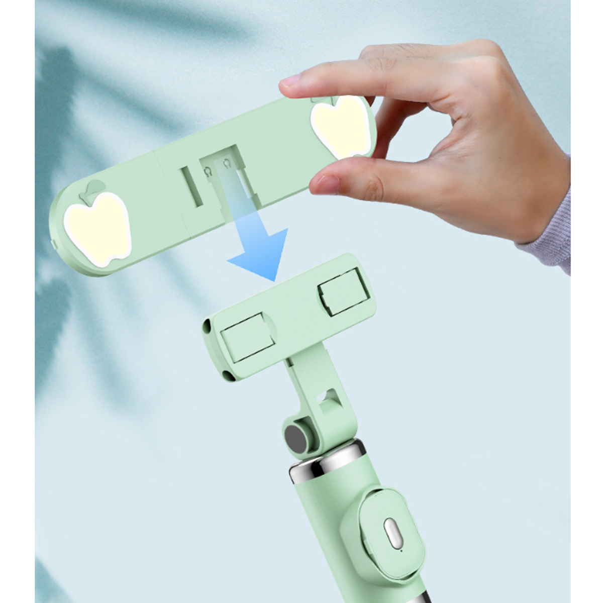 Hand montiert einen grünen Selfie-Stick. Das Gerät ist hellgrün mit Apfelaufklebern.