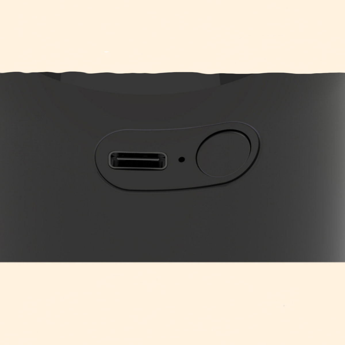 Nahaufnahme eines schwarzen Geräts mit USB-Anschluss und Power-Taste. Der Hintergrund ist hellbeige.
