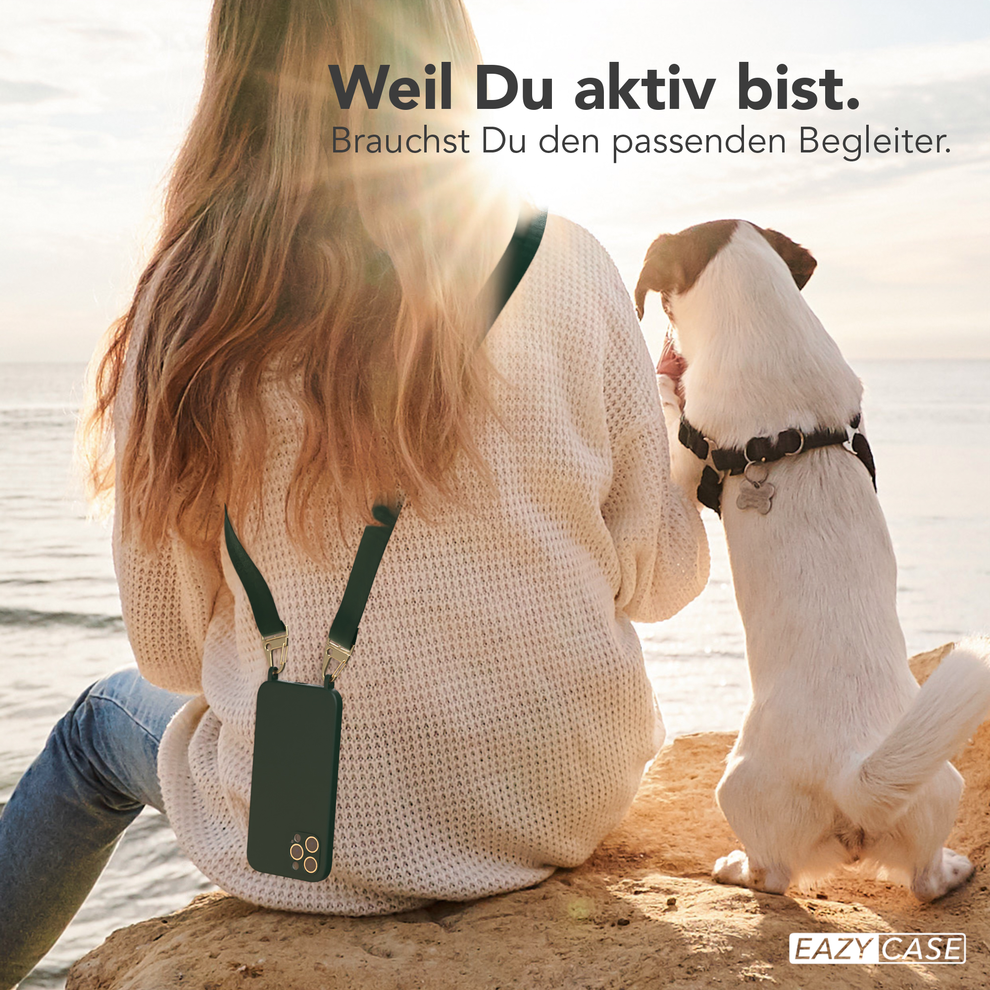 Eine Frau und ein Hund auf einem Felsen, mit einem Telefon in einer Hülle, das an der Frau hängt.