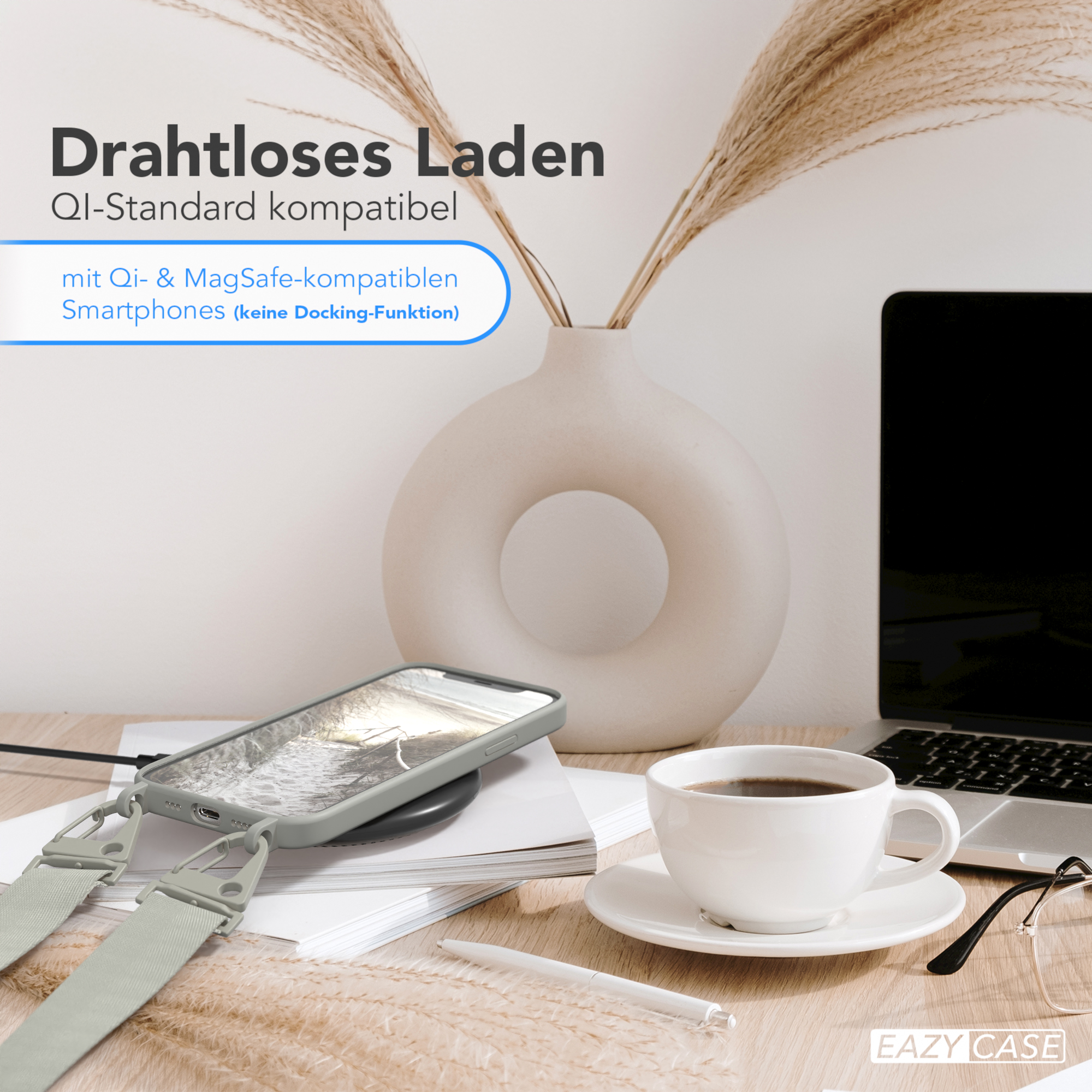 Telefon auf kabellosem Ladegerät, Kaffeetasse und Laptop auf dem Schreibtisch.
