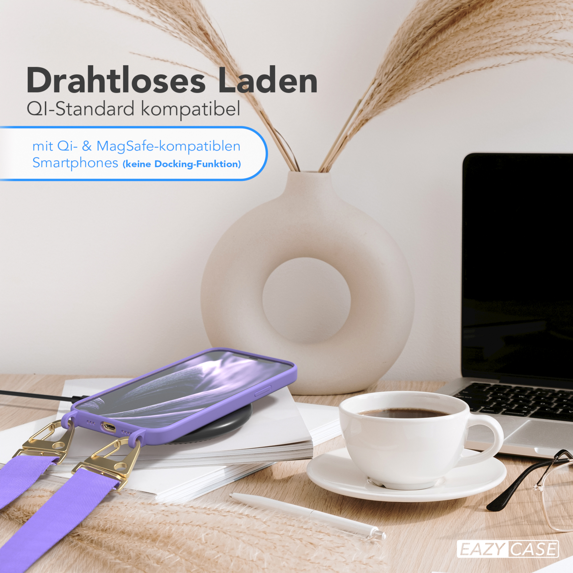 Ein Telefon auf einem kabellosen Ladegerät, neben einer Vase und einer Tasse Kaffee. Ein Laptop im Hintergrund.
