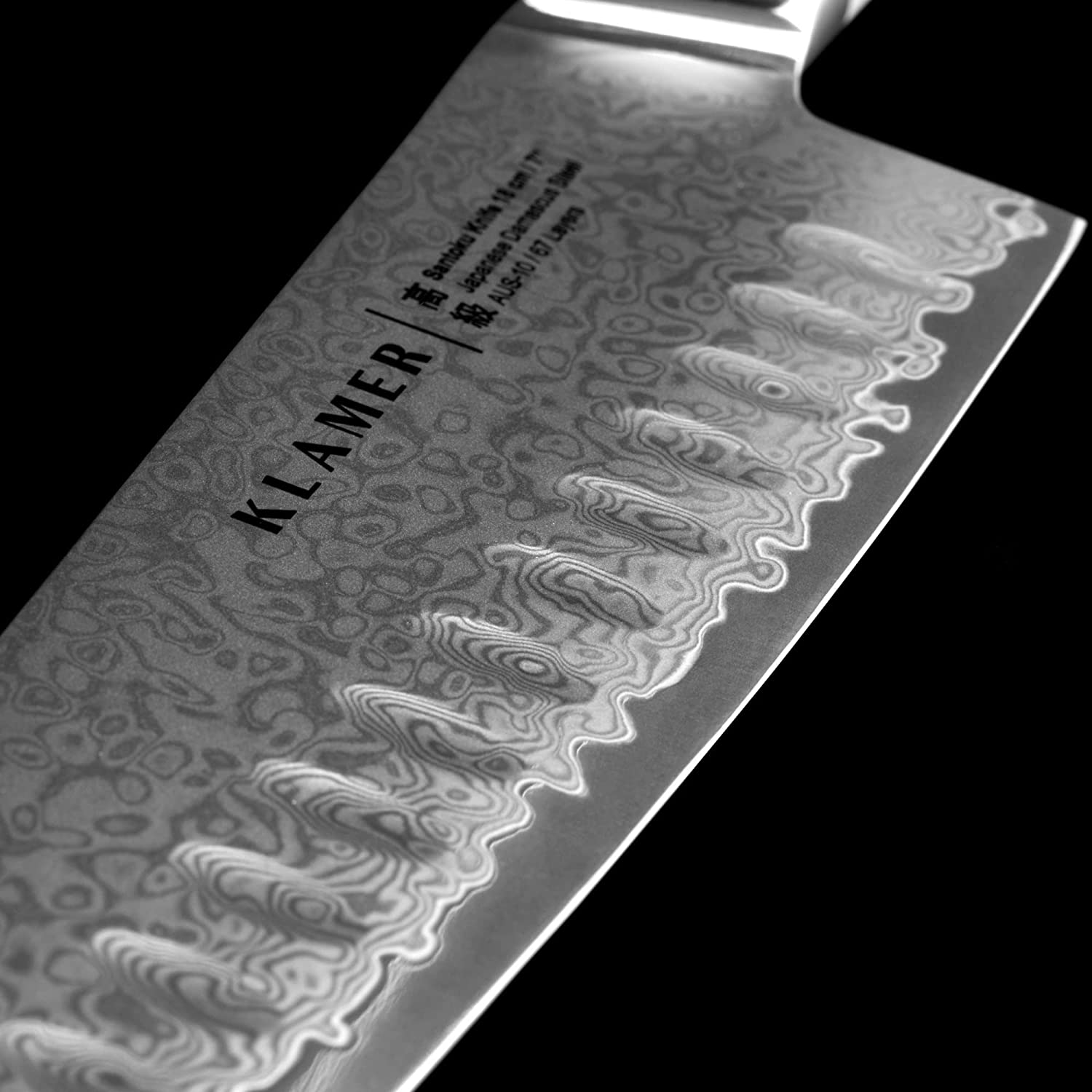 Nahaufnahme einer Messerklinge mit Muster. Der Markenname 'KLAMER' ist sichtbar.