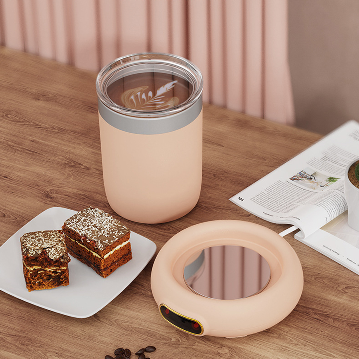 Ein Kaffee-Wärmer mit einer Tasse Kaffee und zwei Gebäckstücken. Der Kaffee-Wärmer ist rosa mit silbernem Rand.