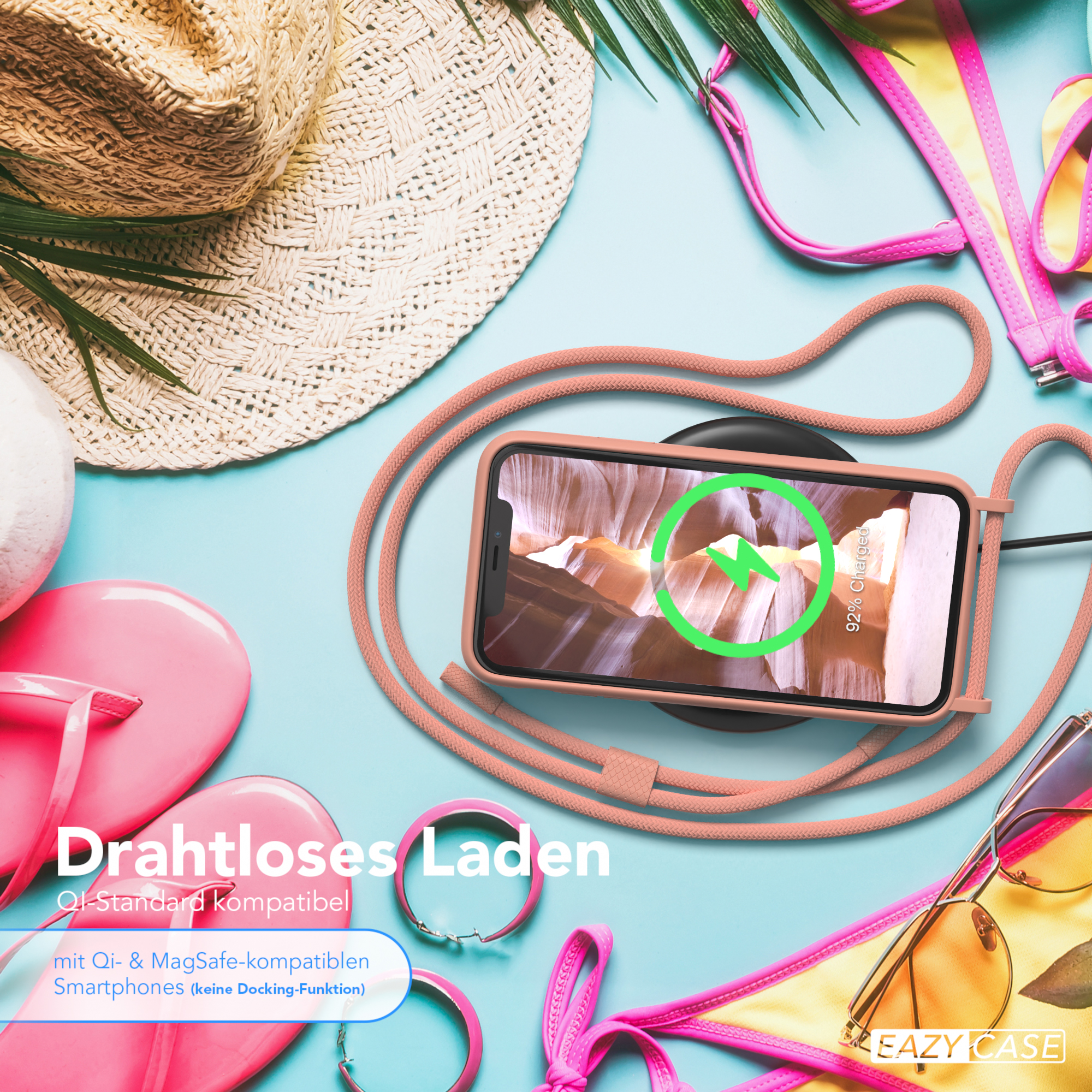 Ein Telefon mit Lanyard auf einem kabellosen Ladegerät, daneben Sonnenbrille und Strandhut.