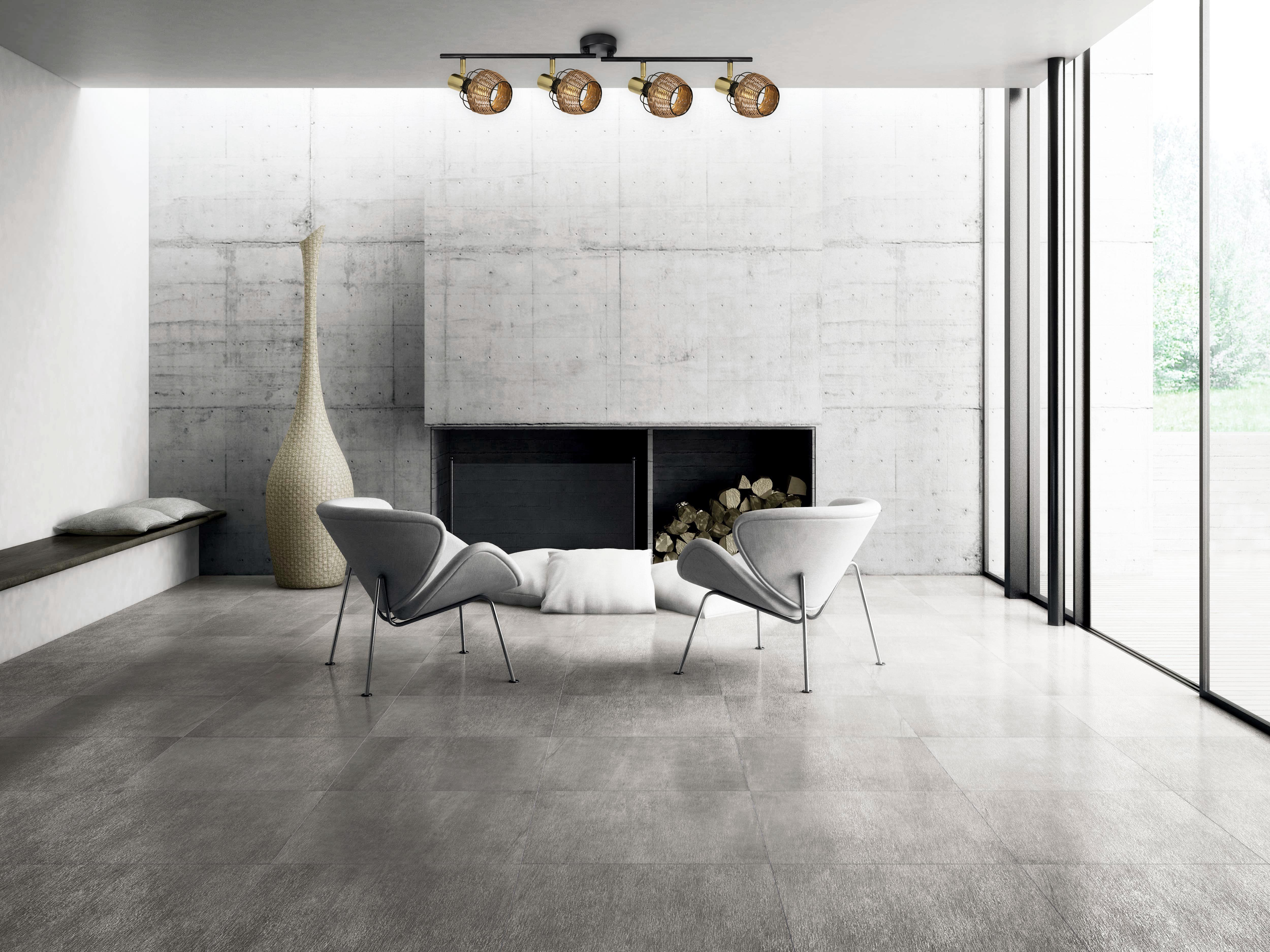 Modernes Wohnzimmer mit grauem Fliesenboden, Betonwänden und einer dekorativen Leuchte.