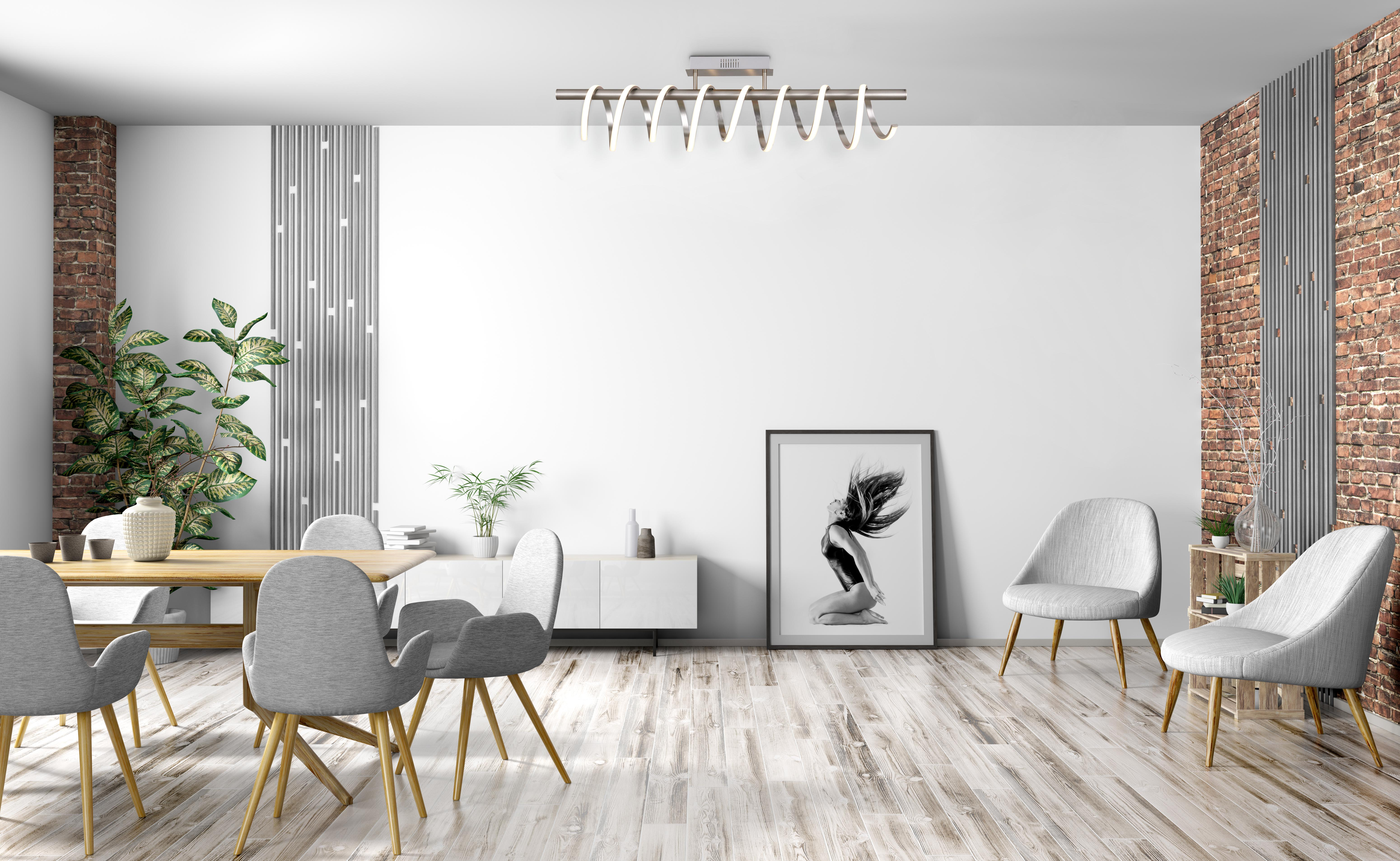 Ein Wohnzimmer mit Holzboden, einer weißen Wand und einem Gemälde. Es gibt Stühle und einen Tisch.