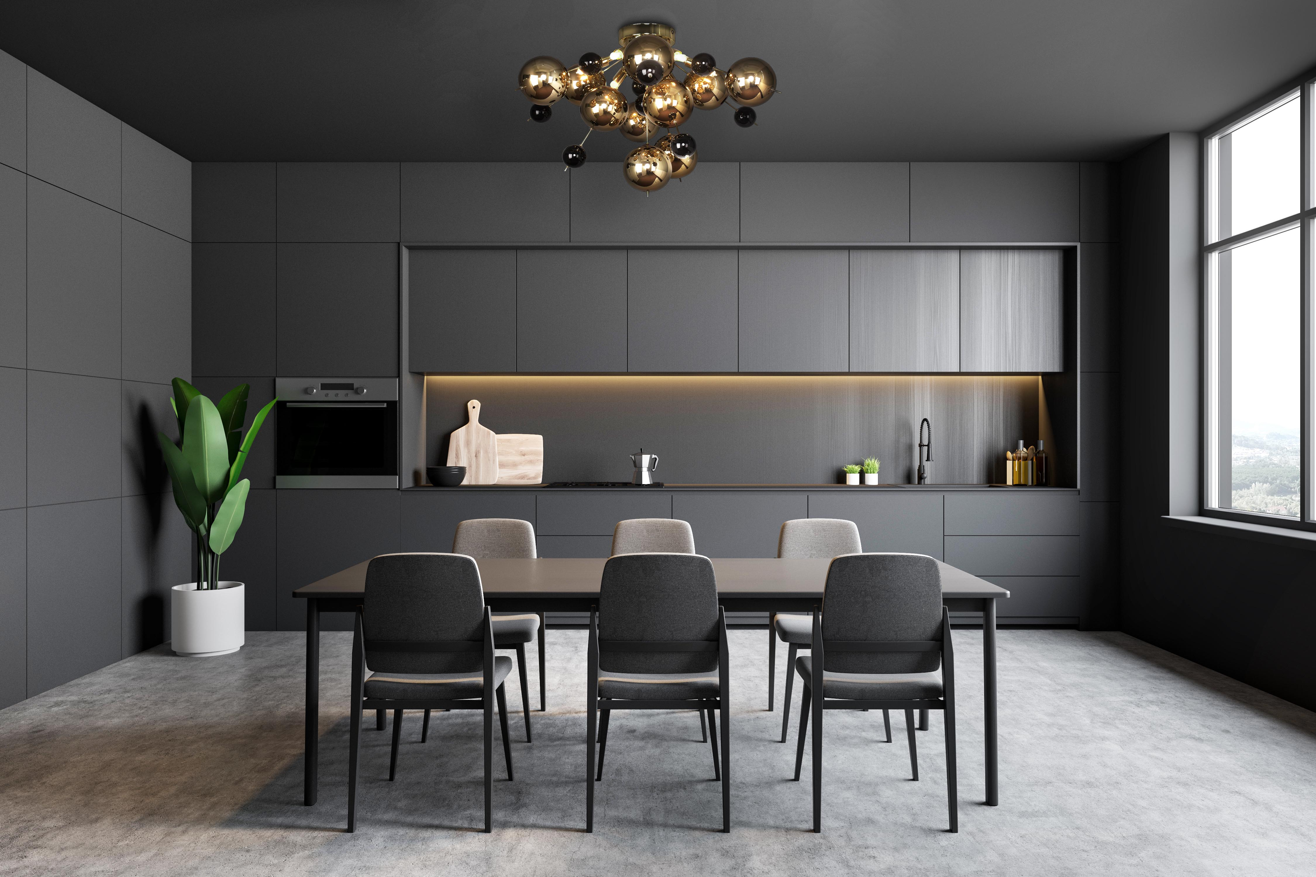 Cuisine grise moderne avec une table à manger. Comprend des placards, des appareils électroménagers, une table avec des chaises et une grande fenêtre.