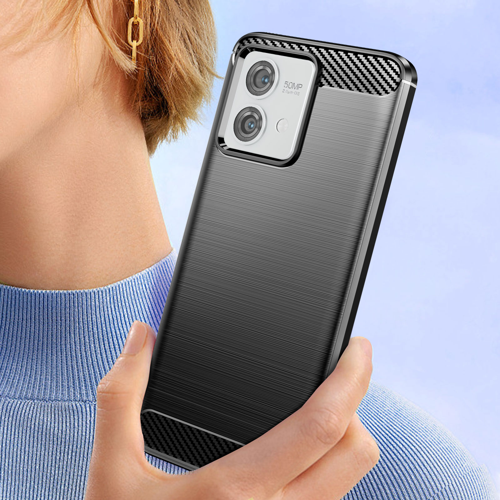 Mano che tiene una custodia del telefono con dettagli della fotocamera e texture su sfondo sfocato.