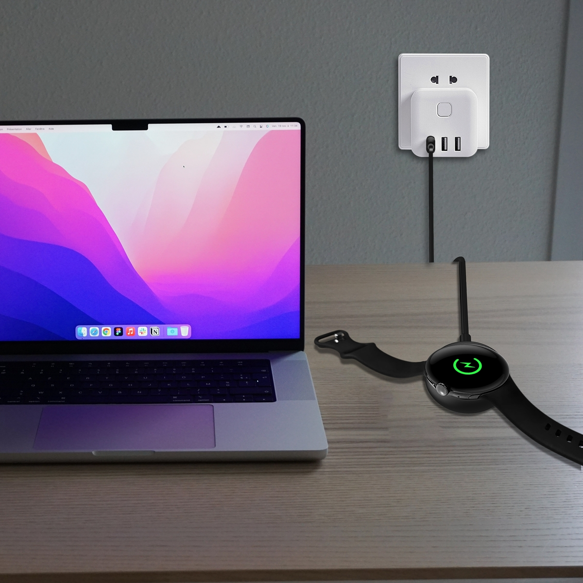 Ein Laptop und eine Smartwatch, die auf einem Holztisch geladen werden, mit einer Steckdose im Hintergrund.