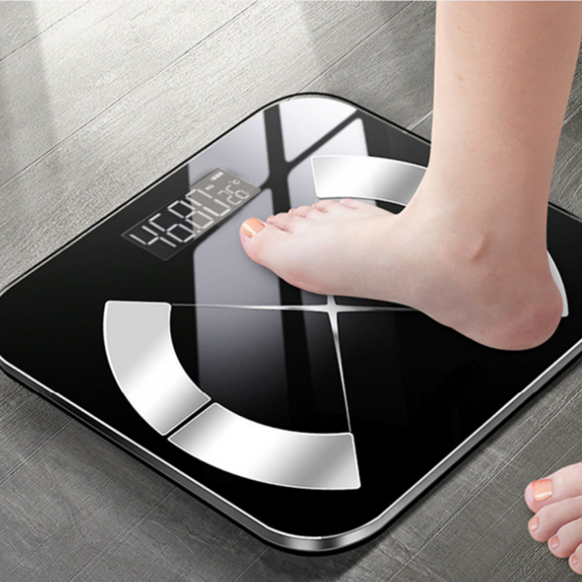 Fuß auf schwarzer Digitalwaage mit 46,80 kg. Ein anderer Fuß ist sichtbar.