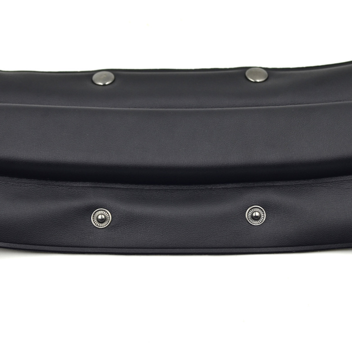 Czarna skóra ze srebrnymi ćwiekami, zakrzywiony kształt, zbliżenie.