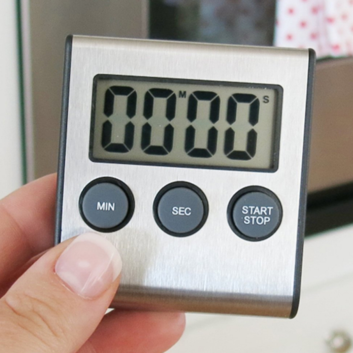 Ein digitaler Küchentimer. Er zeigt 0000 und hat Tasten für Minuten, Sekunden, Start/Stopp.