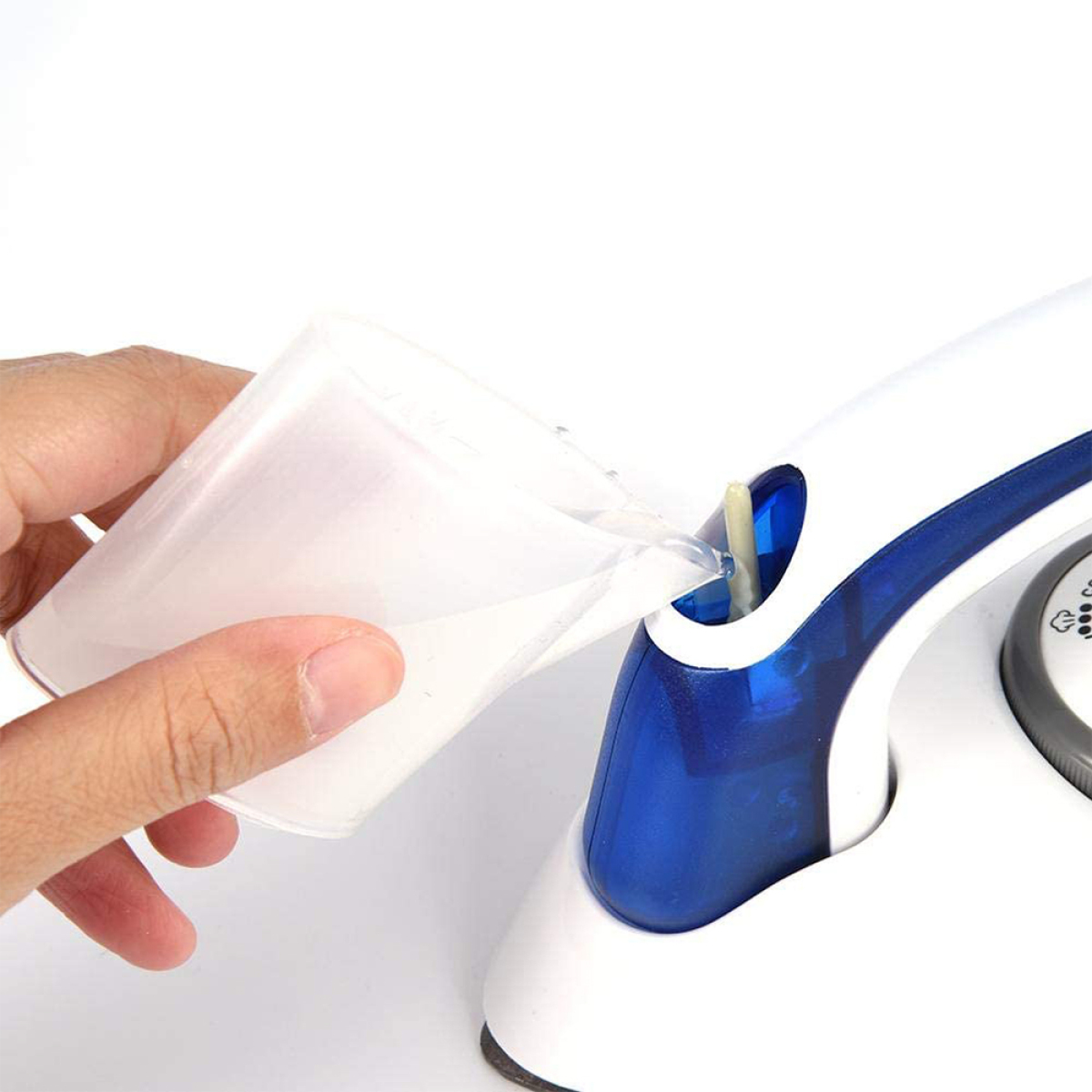 Eine Hand gießt Wasser aus einem transparenten Messbecher in ein blau-weißes Gerät.