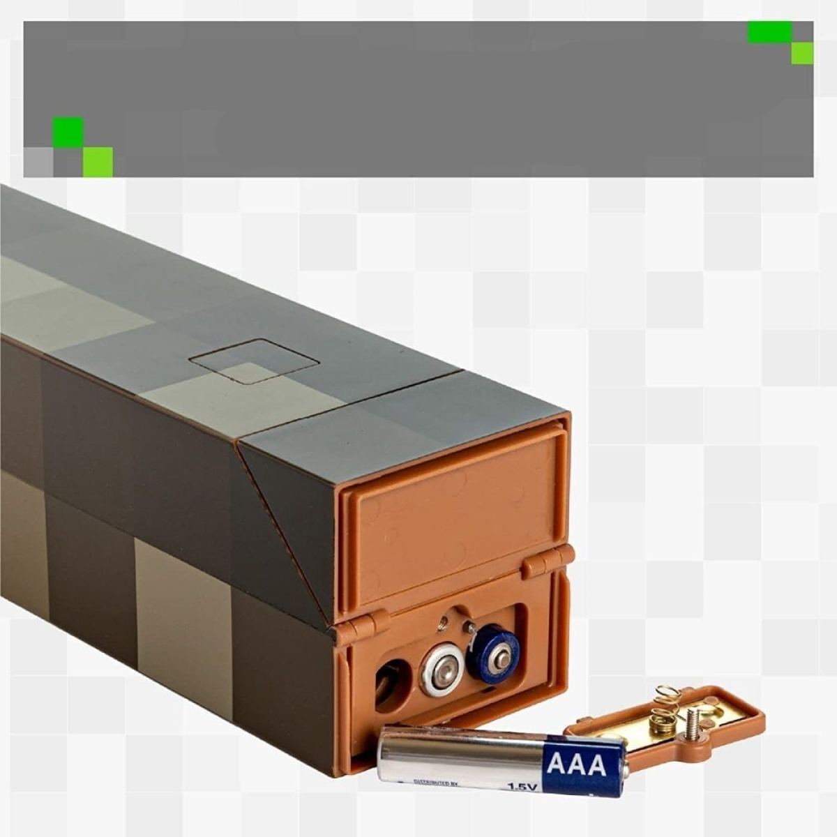 Eine offene Schachtel im Minecraft-Design, die ein Batteriefach mit AAA-Batterien zeigt. Graue und braune Farben.