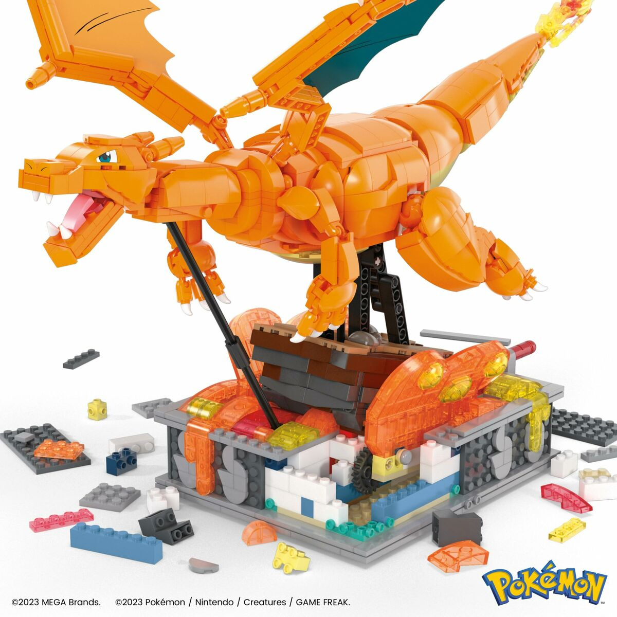 Figurka Charizard LEGO złożona na podstawie, z rozrzuconymi klockami LEGO.