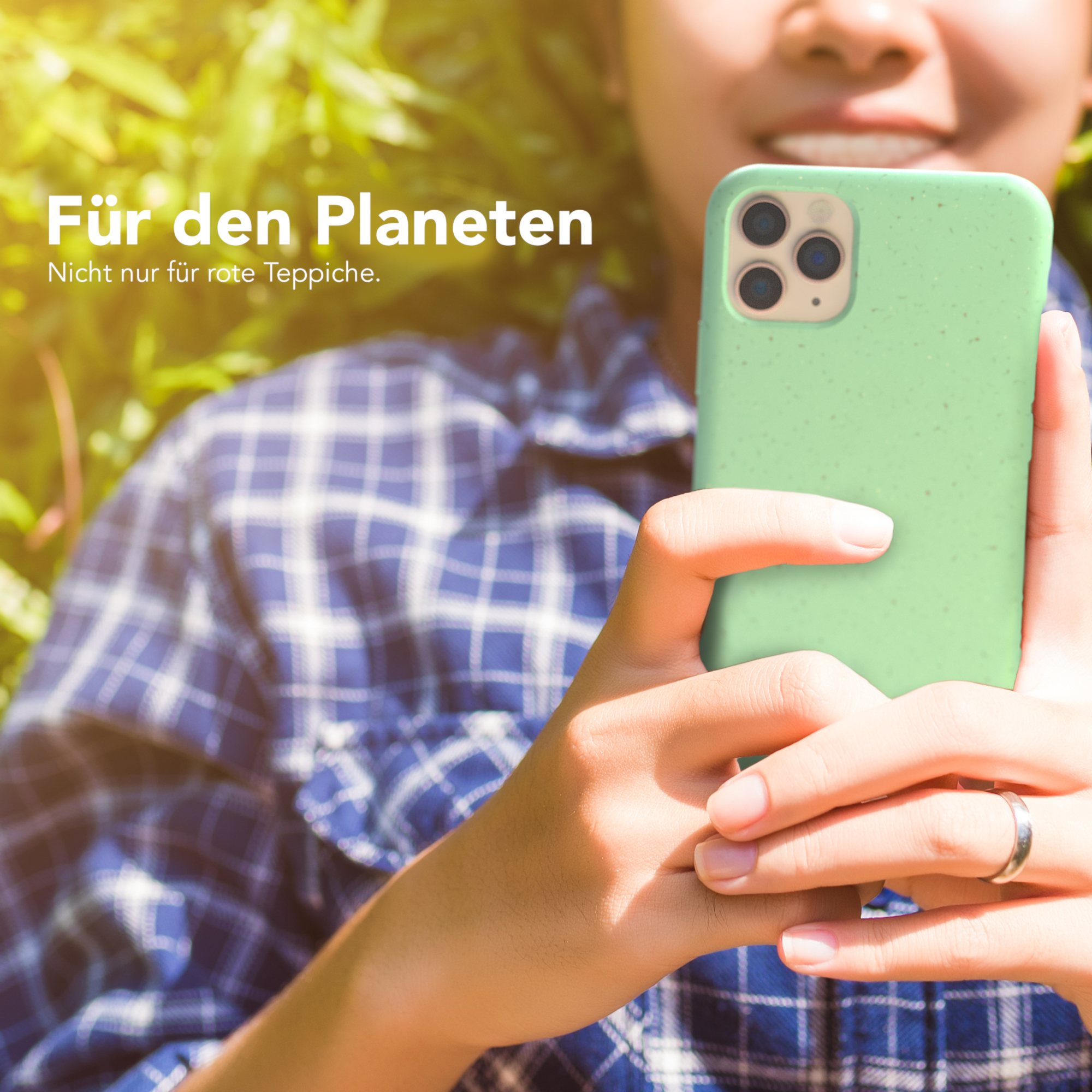 Person hält grüne Handyhülle. Text: 'Für den Planeten', Blatt-Hintergrund.