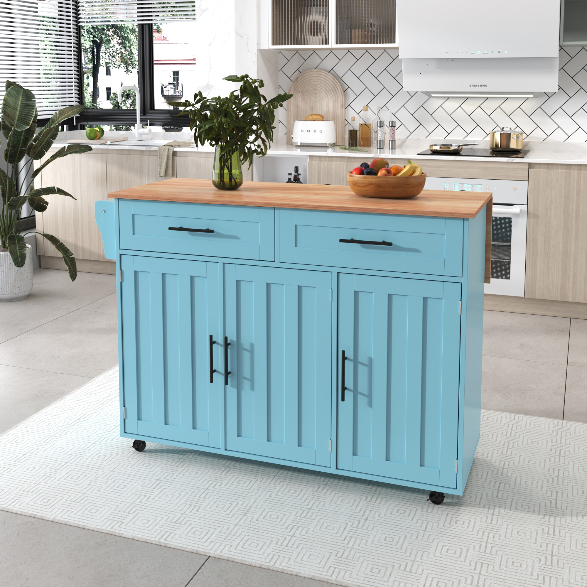 Eine blaue Kücheninsel mit Holzplatte, Schubladen und Schränken. Eine Obstschale steht oben drauf.