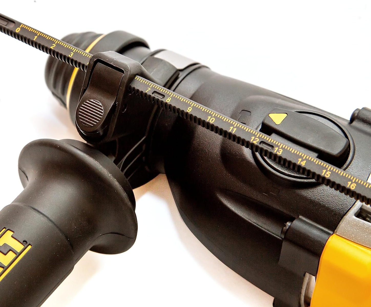 Zbliżenie wiertarki z prowadnicą pomiarową. Wiertarka jest czarna i żółta.