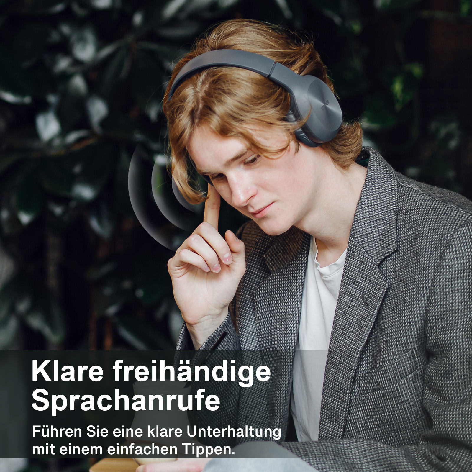 Mężczyzna w słuchawkach dotyka ucha. Tło jest rozmyte.