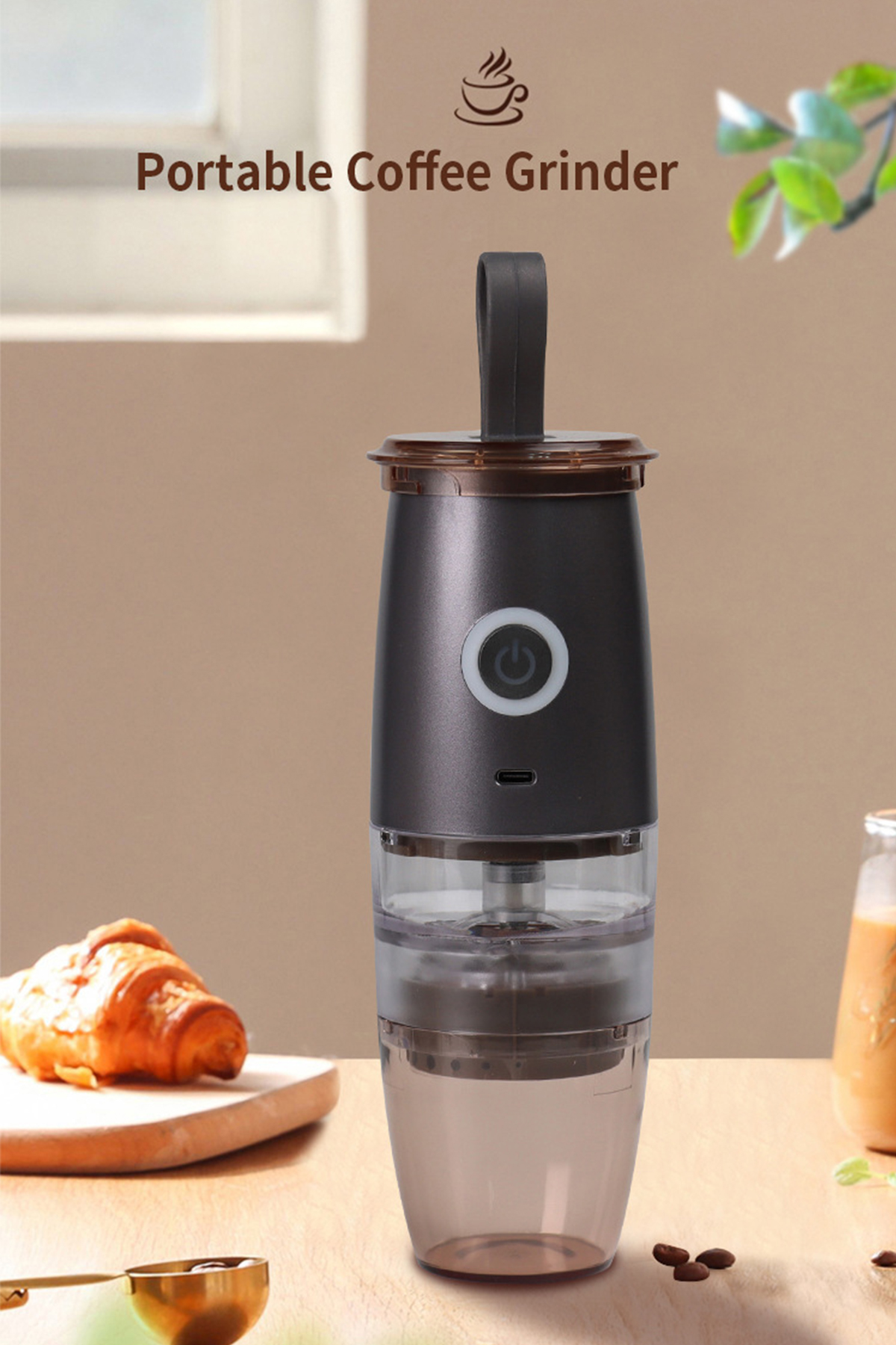 Tragbare Kaffee-Kaffeemühle in Schwarz und Braun. Ein Croissant, Kaffeebohnen und ein Getränk im Hintergrund.