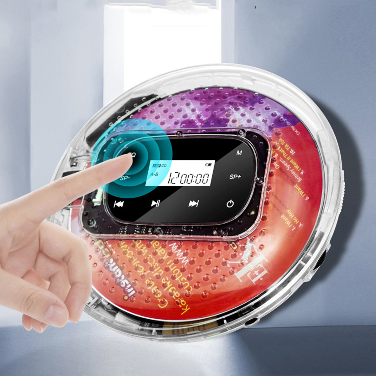 Ein Finger berührt einen kreisförmigen, durchsichtigen CD-Player. Die CD ist darin.