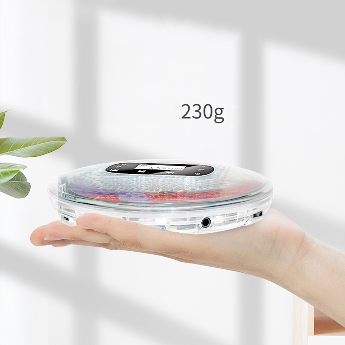 Ein kleiner, klarer CD-Player wird in der Hand gehalten, Gewicht: 230g.