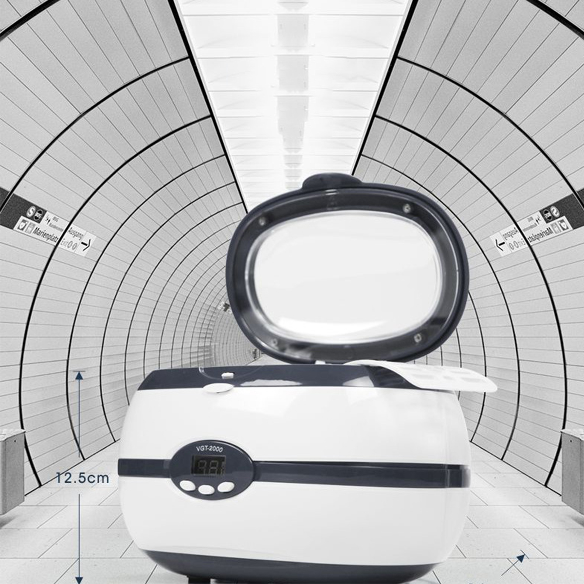 Weiß-graue Reinigungsmaschine. Der Deckel ist offen. Der Hintergrund ist ein U-Bahn-Tunnel.