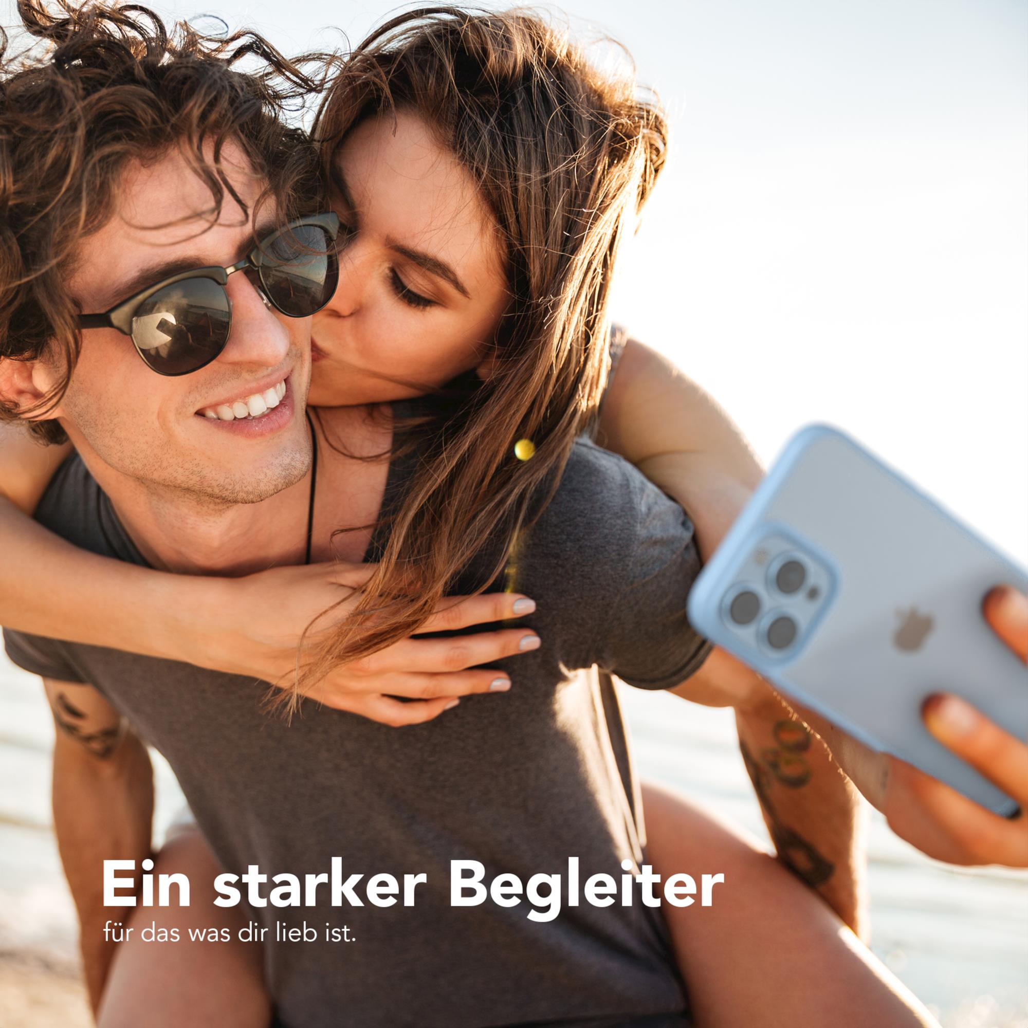 Ein Paar in einer sonnigen Szene. Die Frau küsst den Mann auf die Wange.