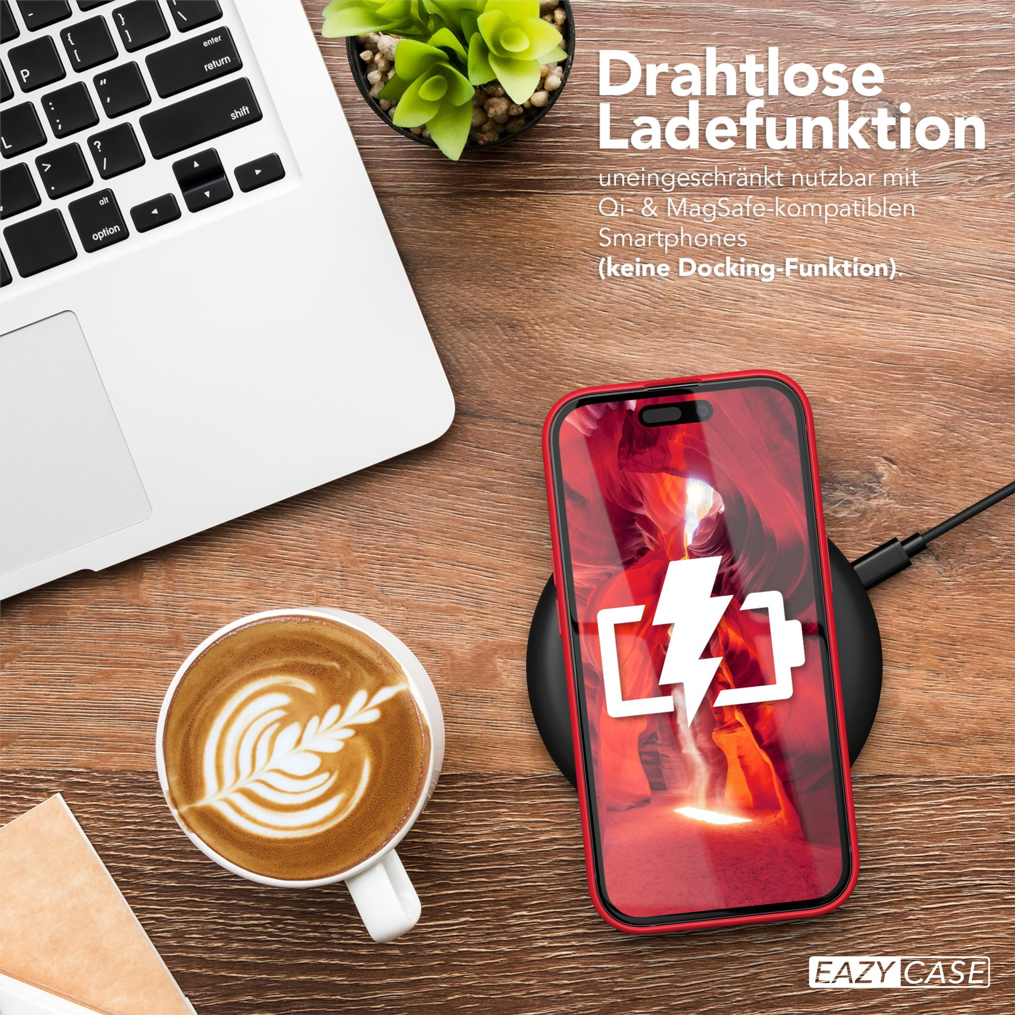 Ein rotes Telefon auf einem schwarzen kabellosen Ladegerät, mit einem Laptop und einer Kaffeetasse auf einem Holztisch.
