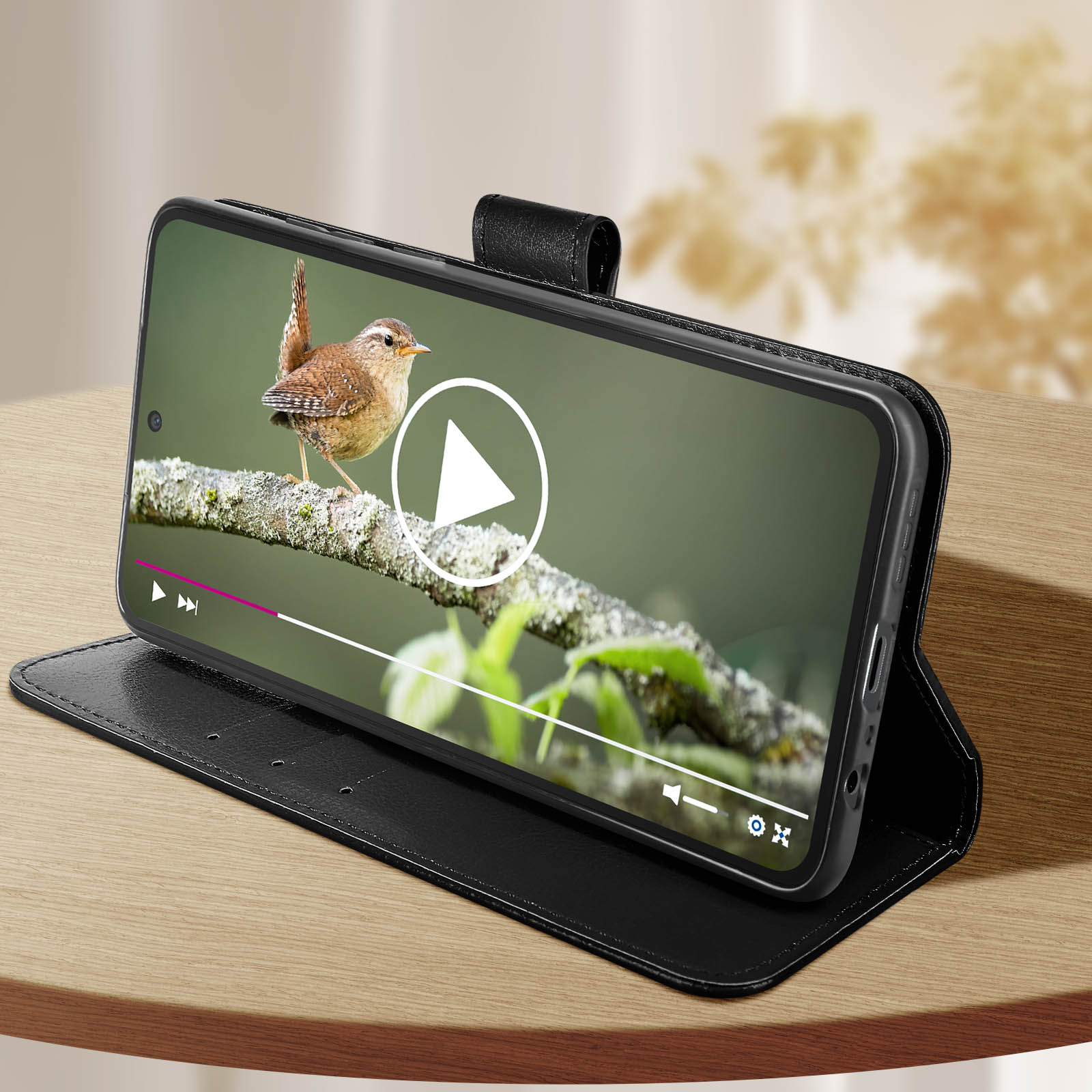 Ein Telefon in einer schwarzen Hülle ist geöffnet und zeigt ein Video eines Vogels. Der Bildschirm hat Videosteuerung.