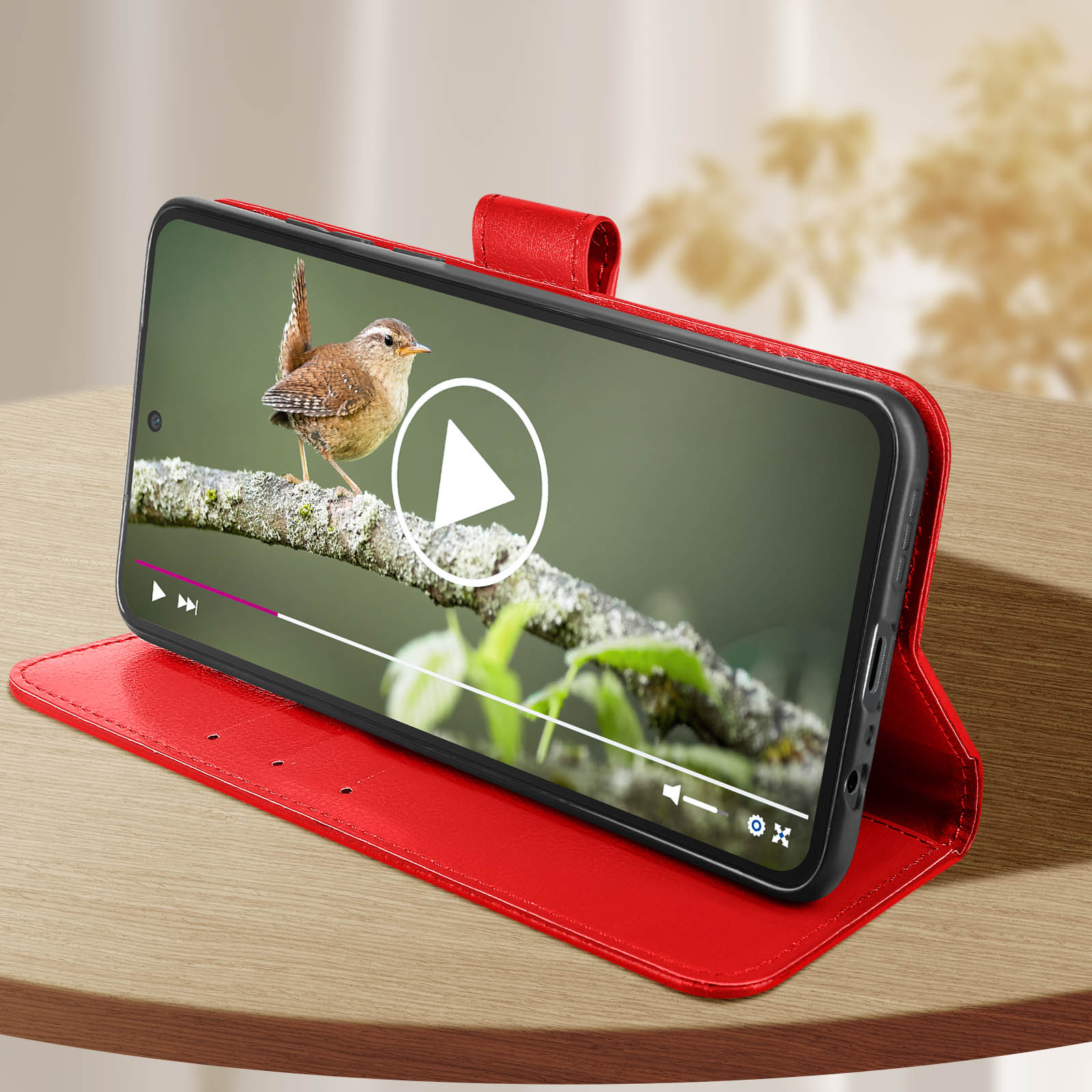 Ein Telefon, das ein Video eines Vogels auf einem Ast in einer roten Hülle zeigt.