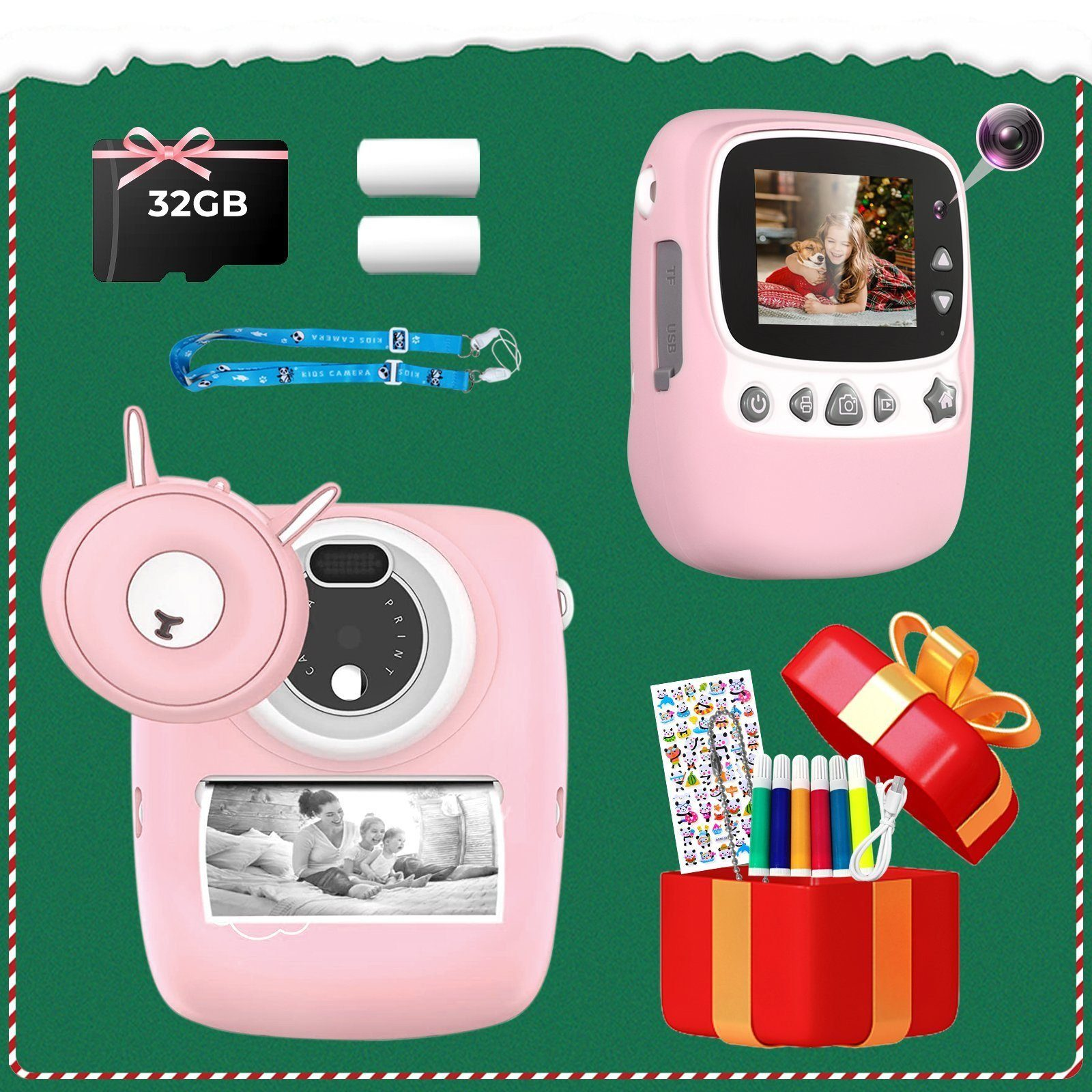 Set de cámara rosa: cámara, tarjeta de memoria, pilas y caja de regalo con marcadores. Fondo verde.