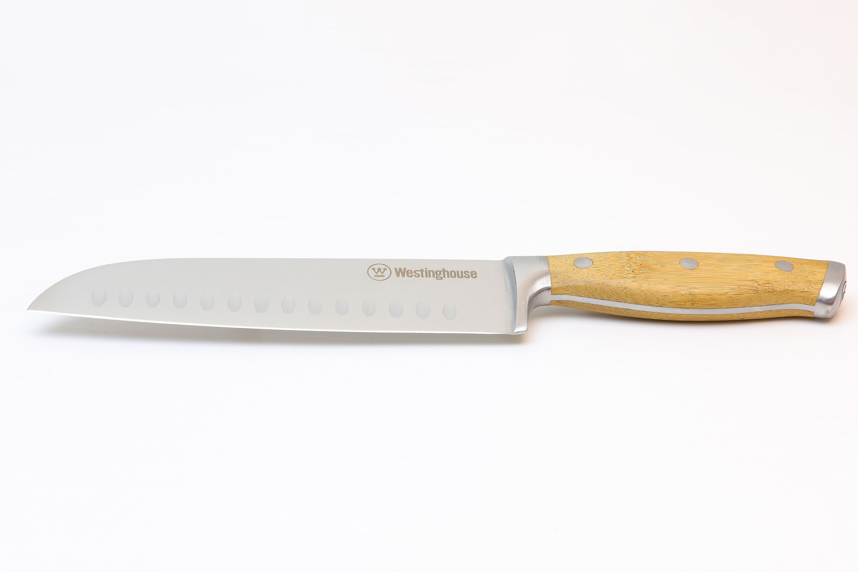 Ein Küchenmesser, das Karotten auf einem Holzschneidebrett mit Gemüse schneidet.