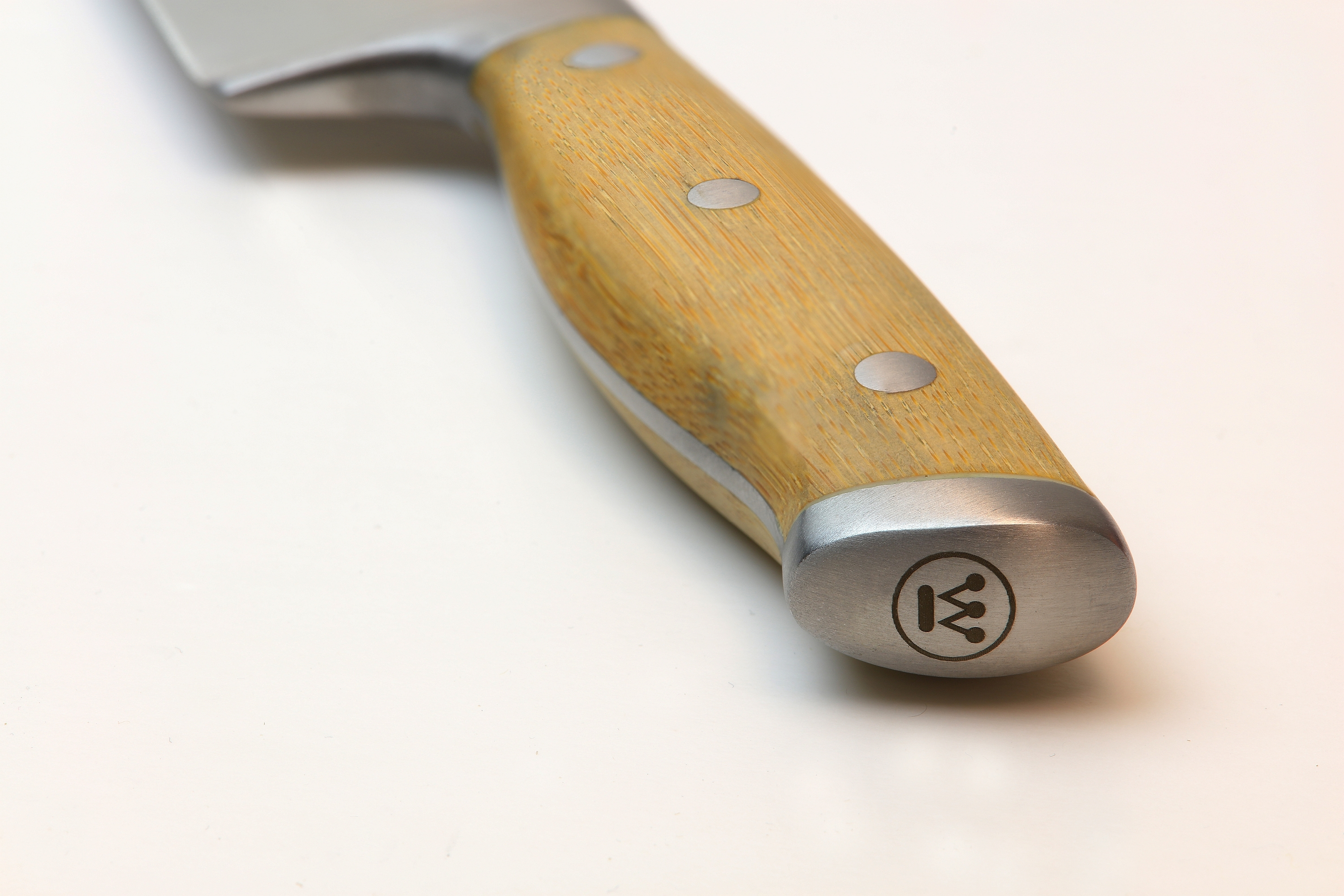 Nahaufnahme eines Messergriffs, Holz mit Metallnieten und Endkappe, die ein Kronenlogo trägt.