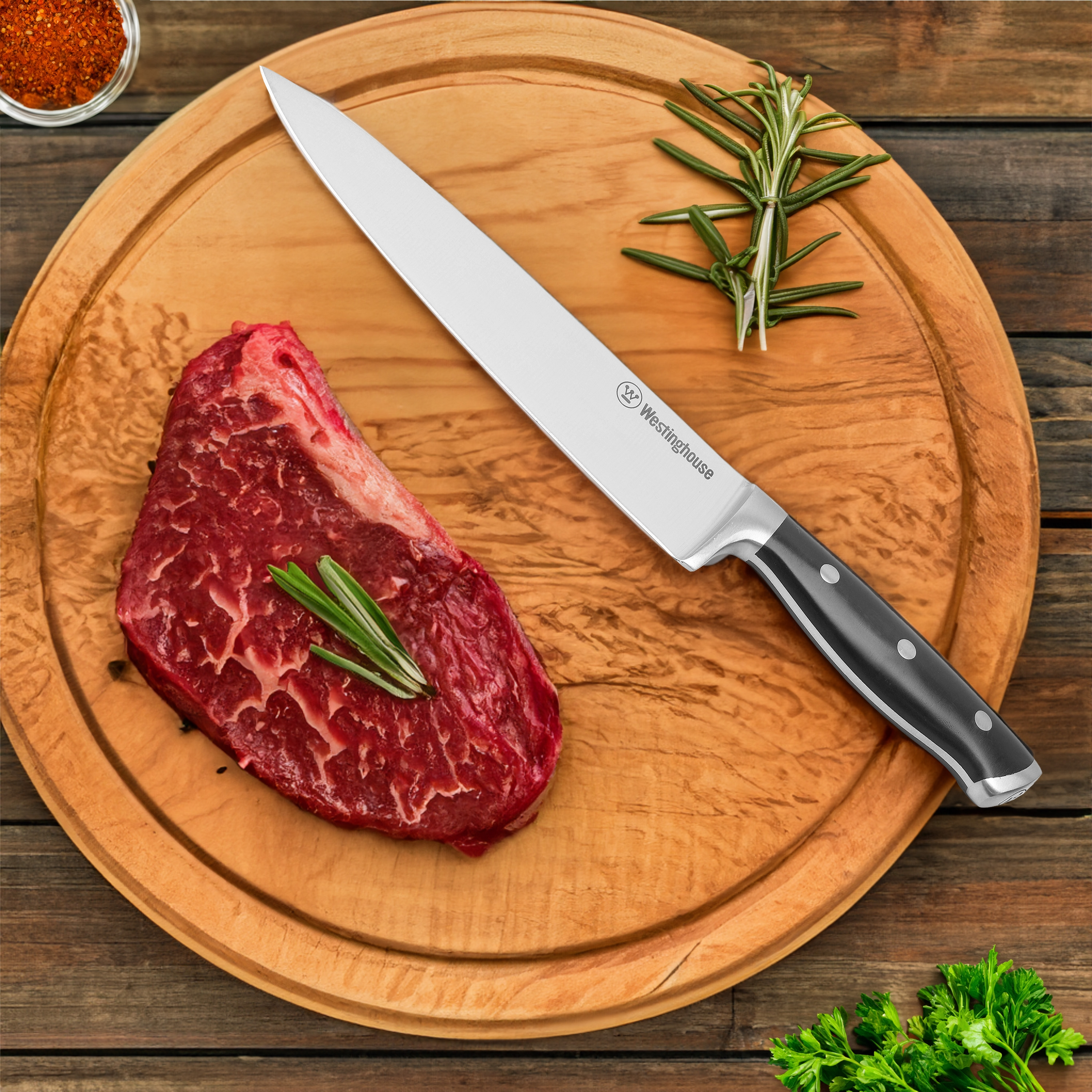 Ein Steak mit einem Messer auf einem hölzernen Schneidebrett, mit Gewürzen und Rosmarin.